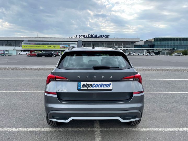 Automašīna ir novietota stāvvietā lidostas priekšā.