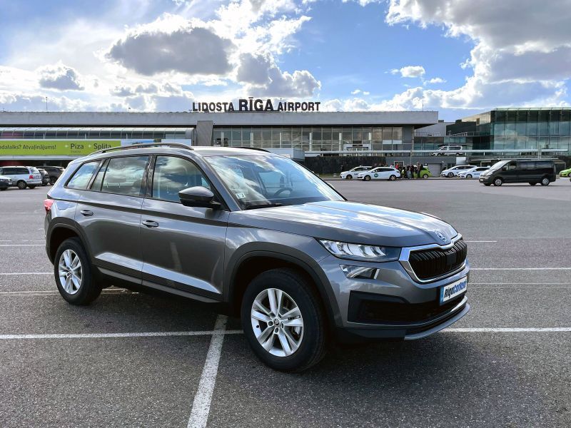 Skoda Kodiaq ir novietota autostāvvietā lidostas priekšā.