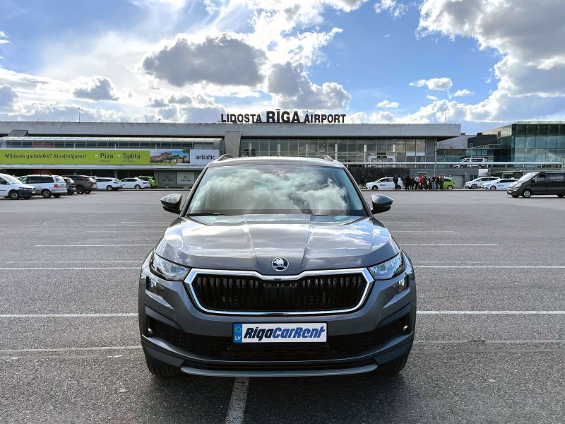 Skoda Kodiaq ir novietota autostāvvietā lidostas priekšā.