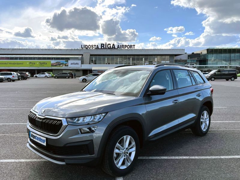Skoda Kodiaq ir novietota autostāvvietā lidostas priekšā.