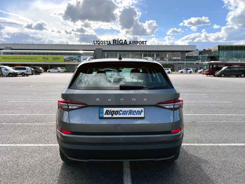 Škoda automašīna ir novietota stāvvietā lidostas priekšā