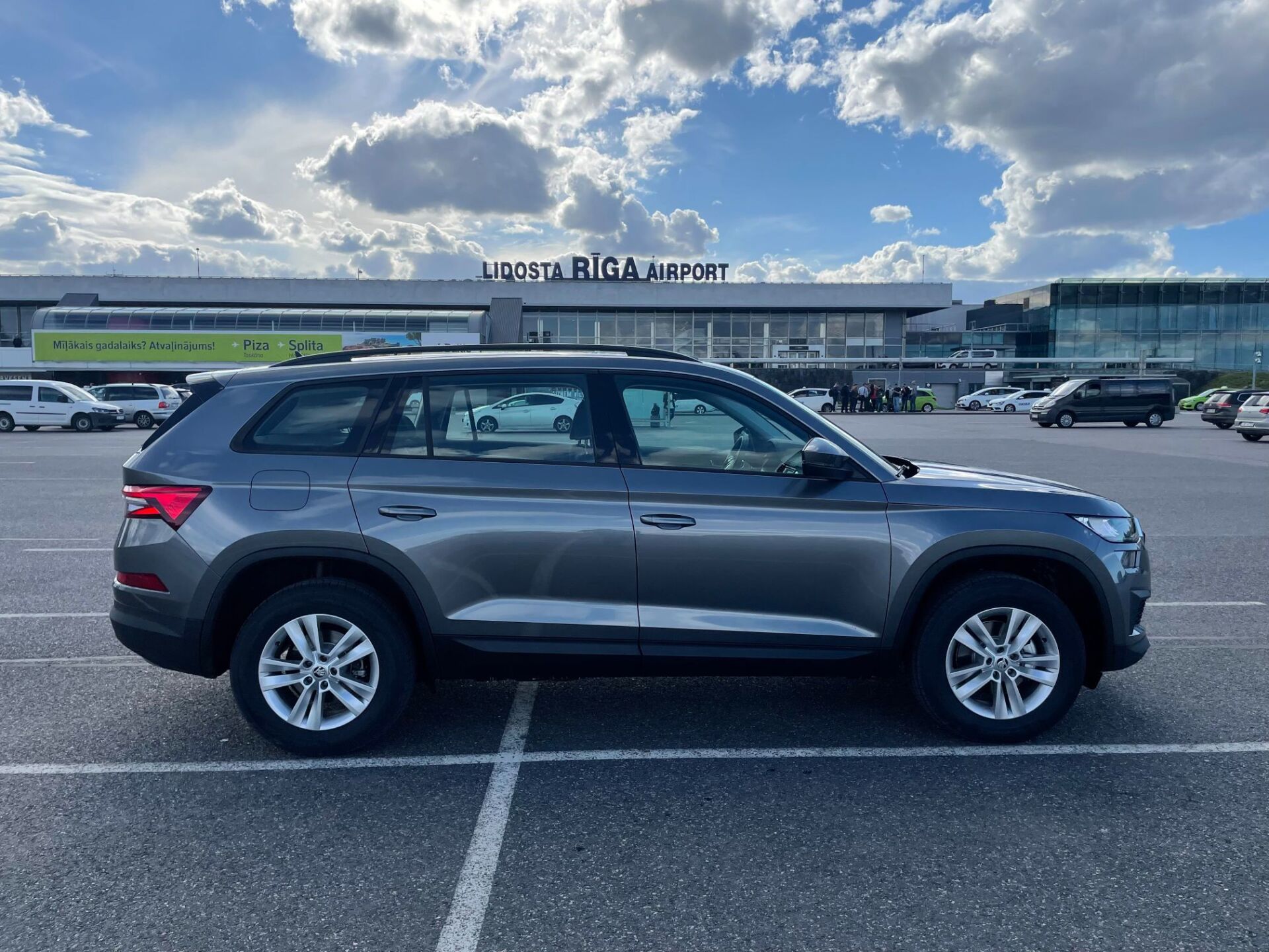 Skoda Kodiaq ir novietota stāvvietā ēkas priekšā.