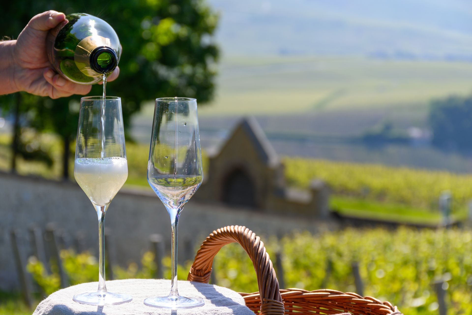 Une personne verse du champagne dans deux verres sur une table.
