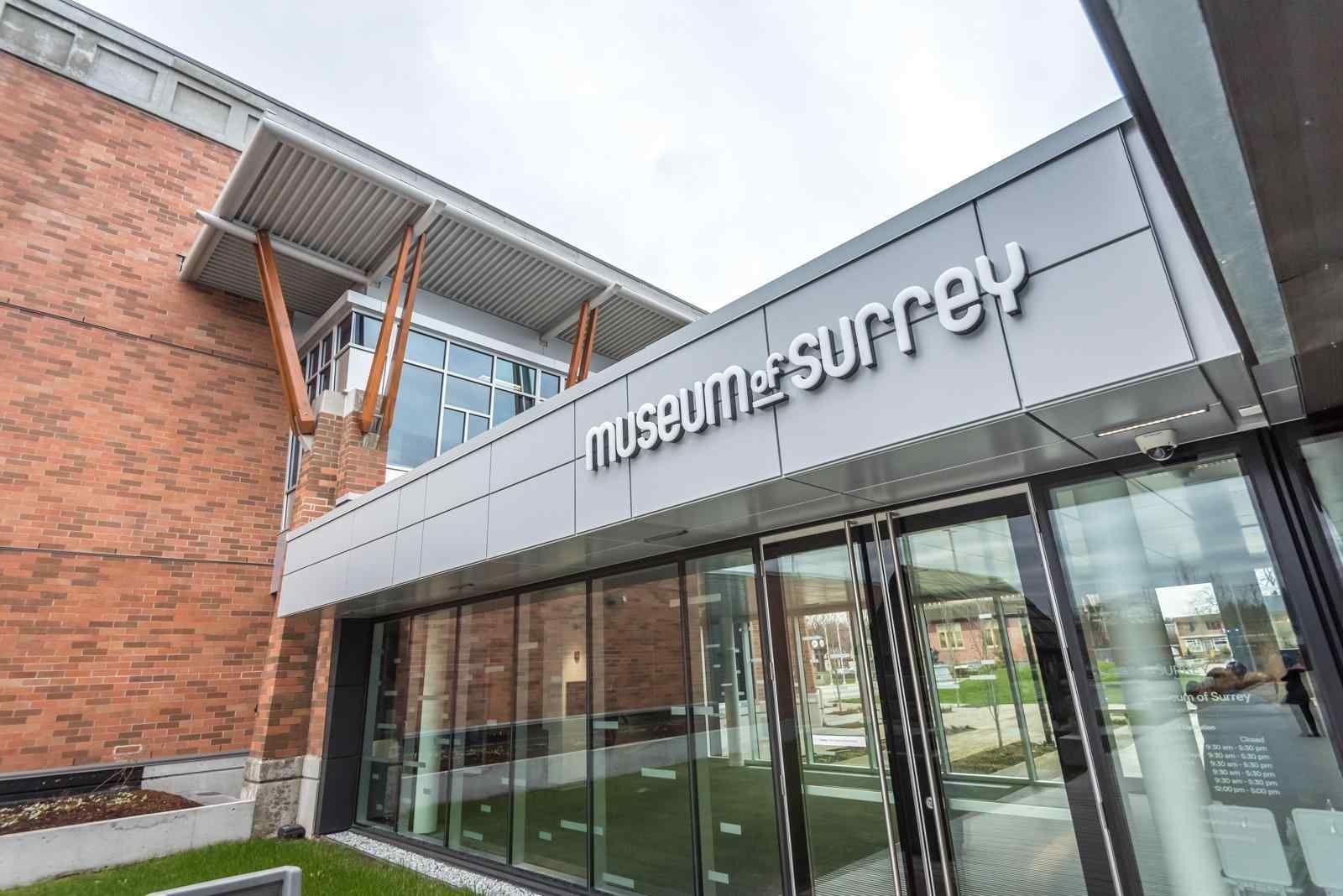 Museum Surrey entrance with glass doors and brick-and-metal exterior signage