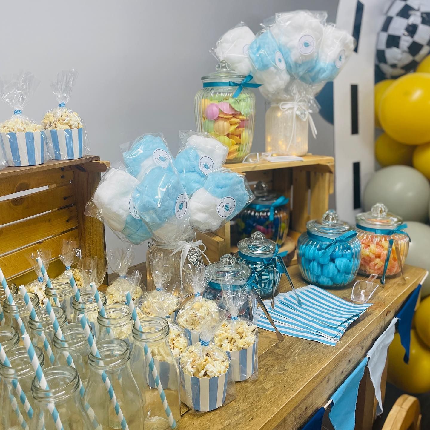 a table filled with candy , popcorn , and cotton candy .
