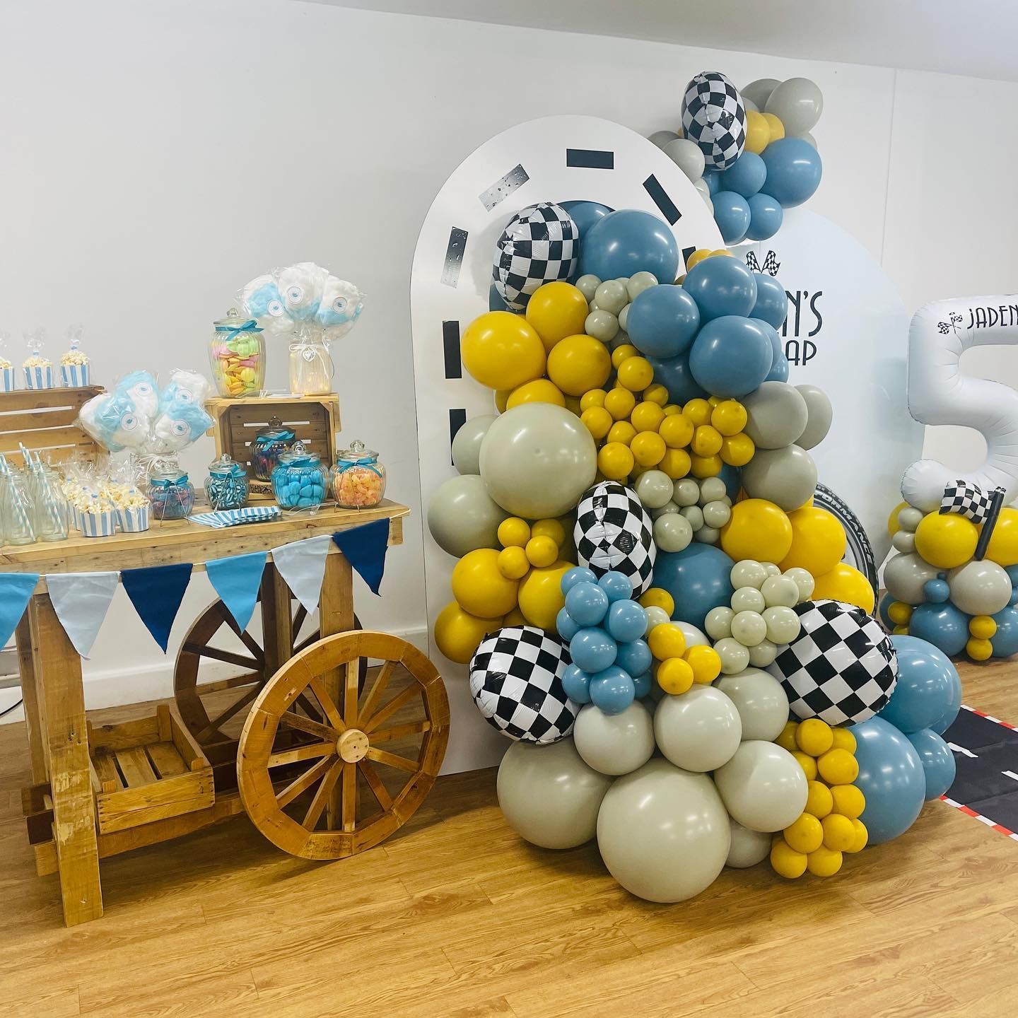 a bunch of balloons are sitting on a wooden floor next to a wooden cart .