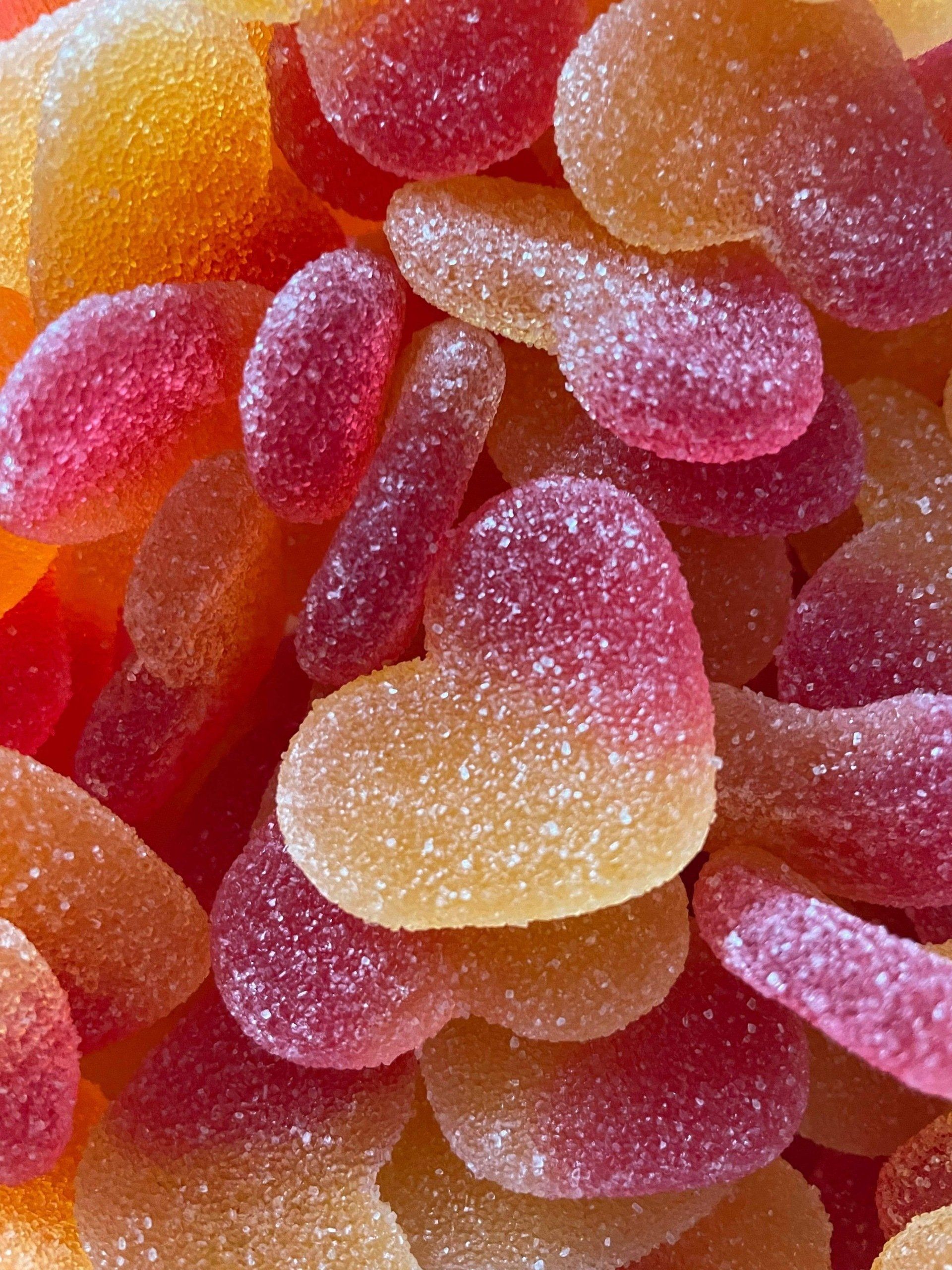 A close up of a pile of heart shaped gummy candies.