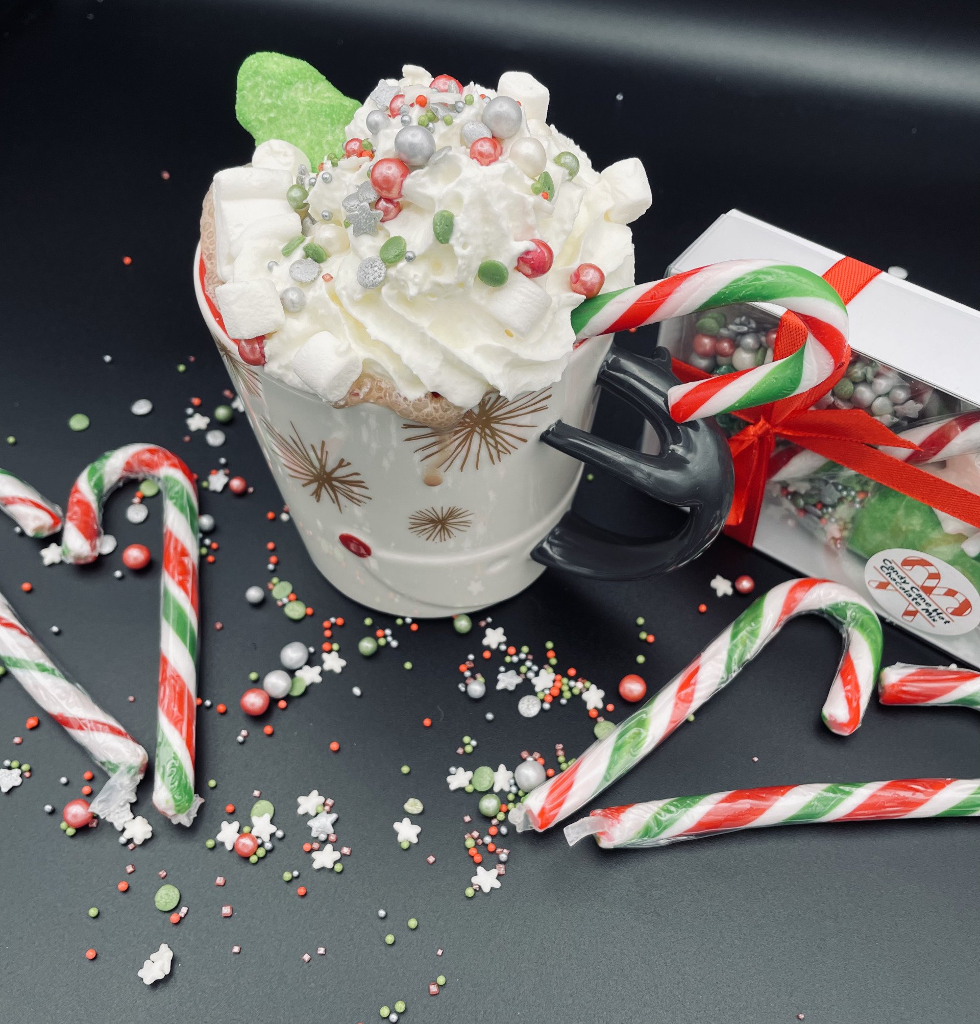 A cup of hot chocolate with whipped cream and candy canes
