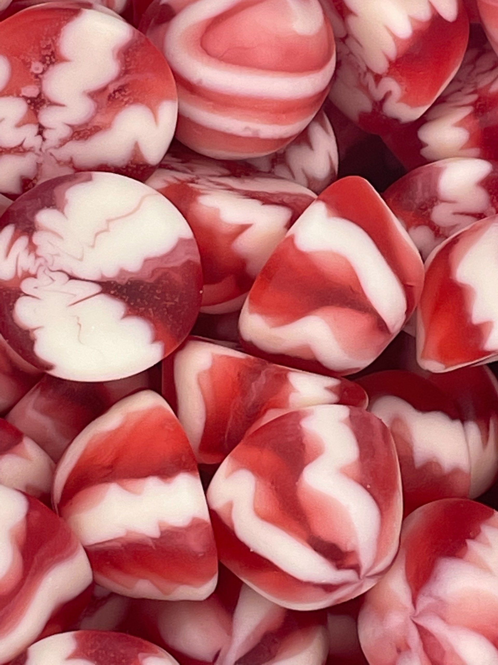 A pile of red and white candy with a swirl pattern