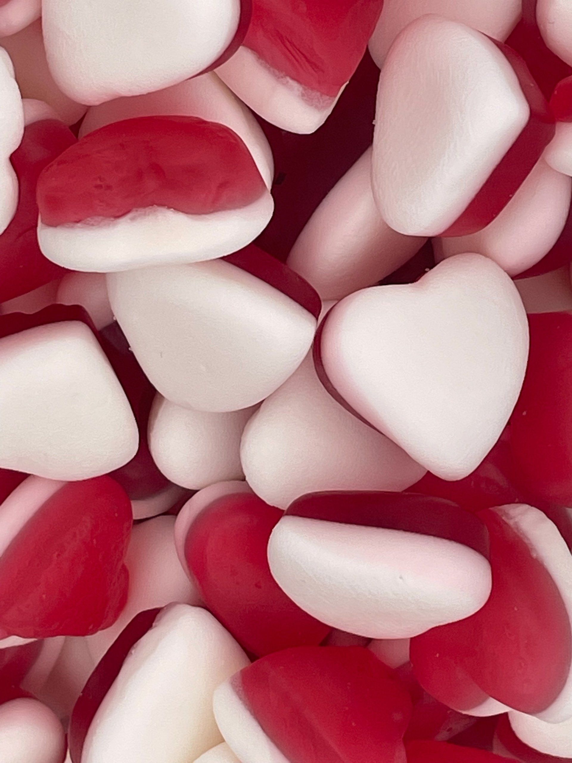 A pile of red and white heart shaped candy