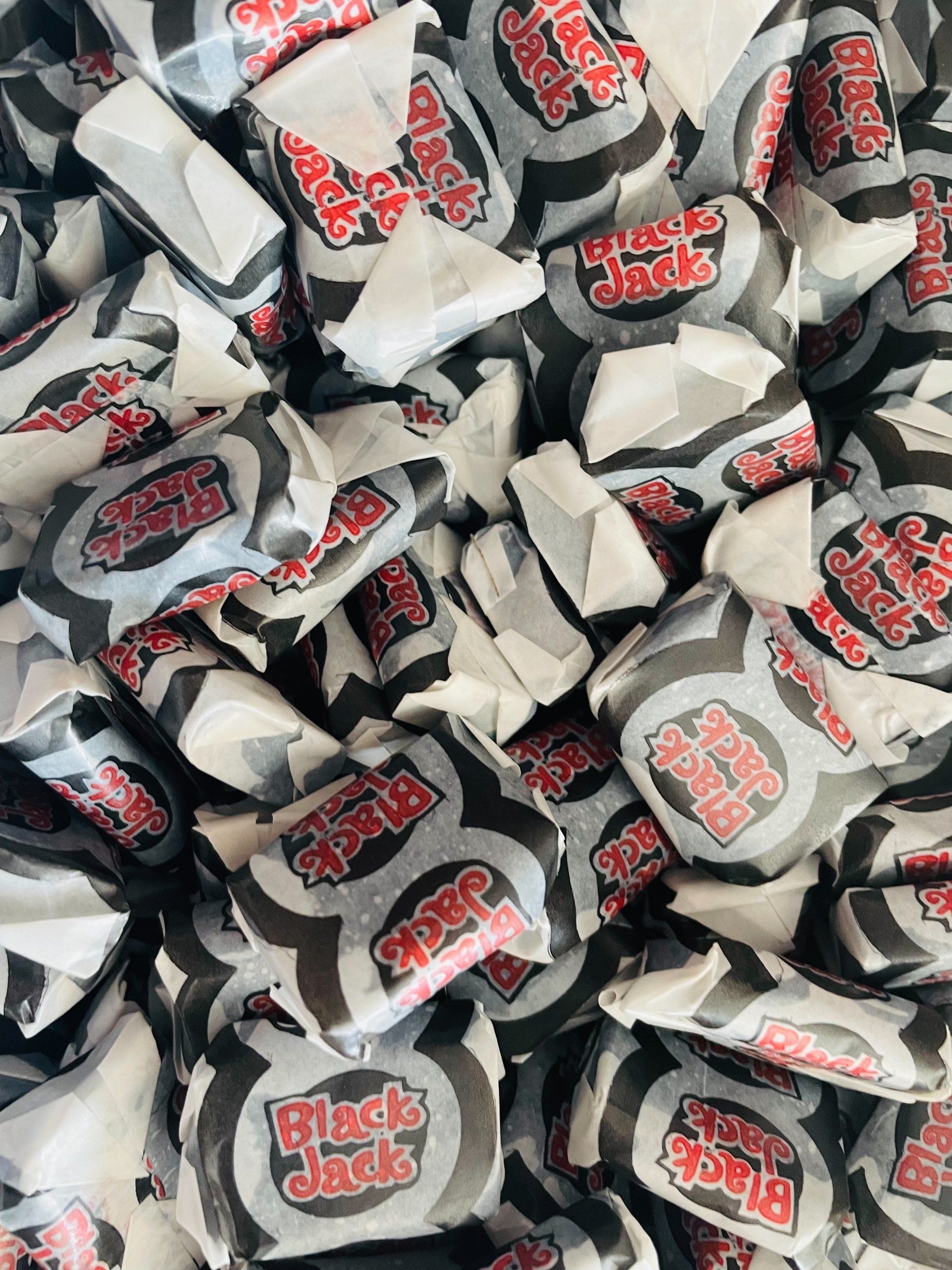 A pile of black jack candy is sitting on top of each other on a table.