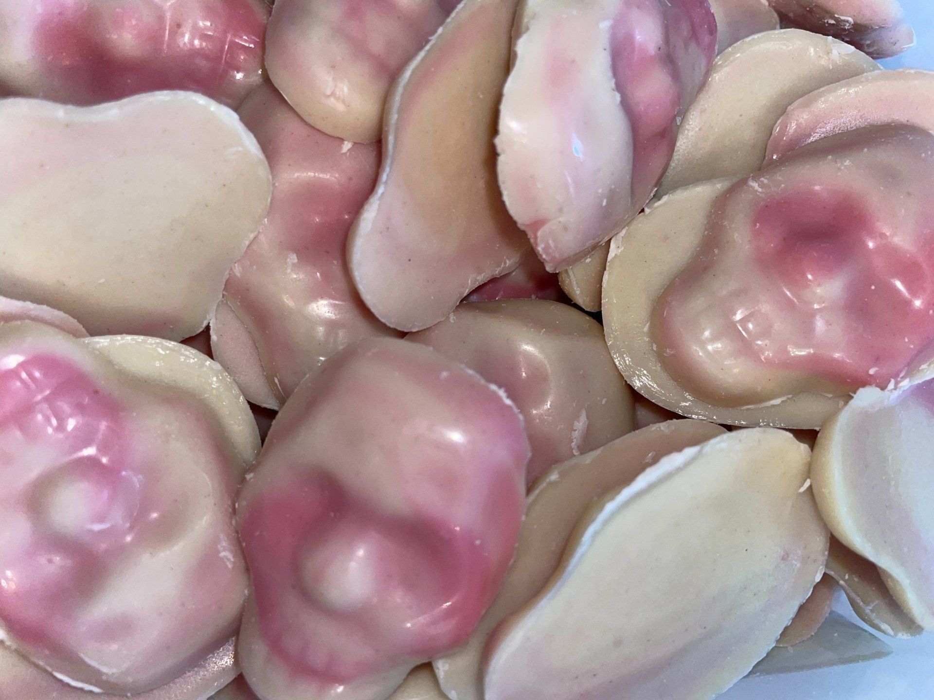 A pile of pink and white candy shaped like skulls