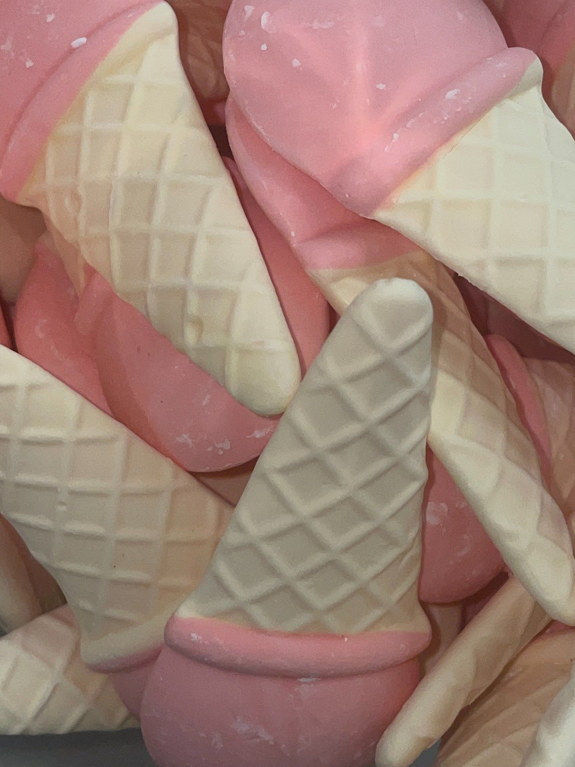 A pile of pink and white ice cream cones
