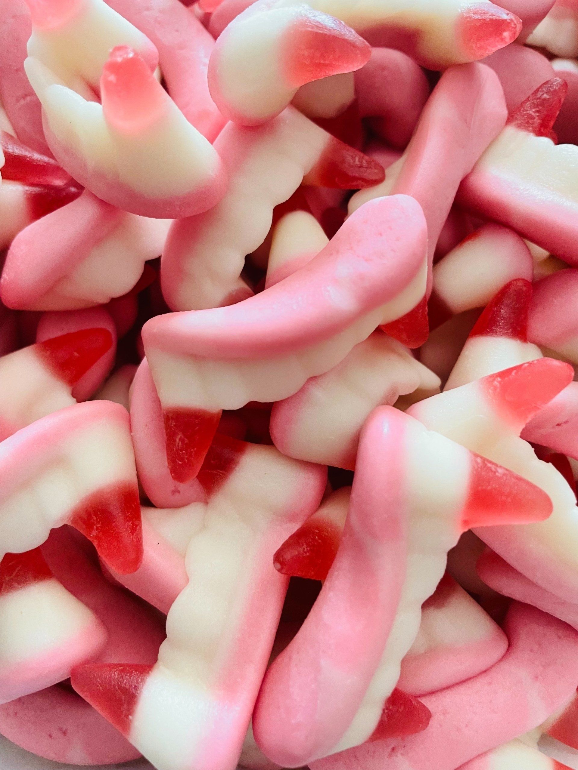 A pile of pink and white gummy vampire teeth