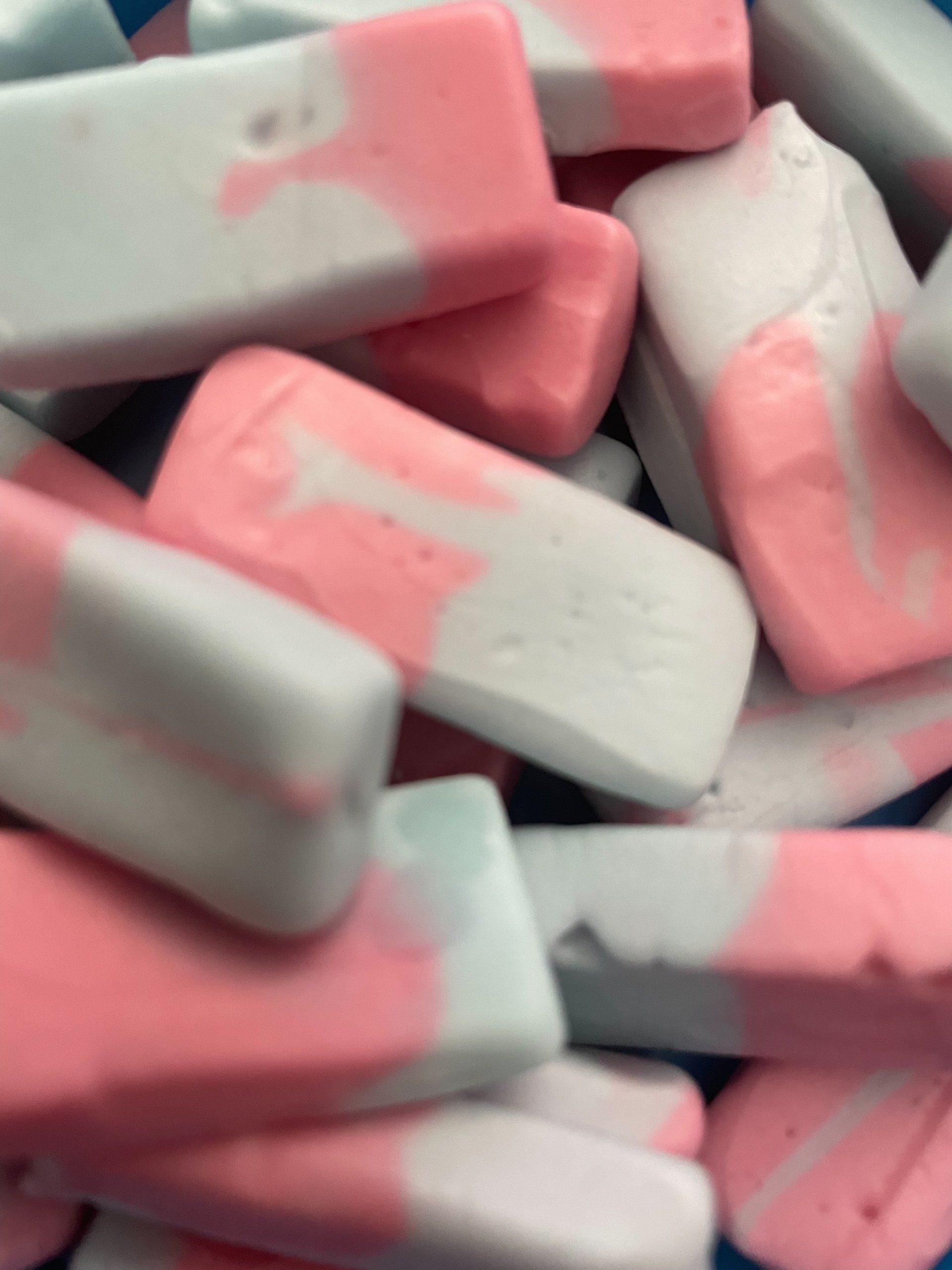 A pile of pink and white erasers with the letter t on them