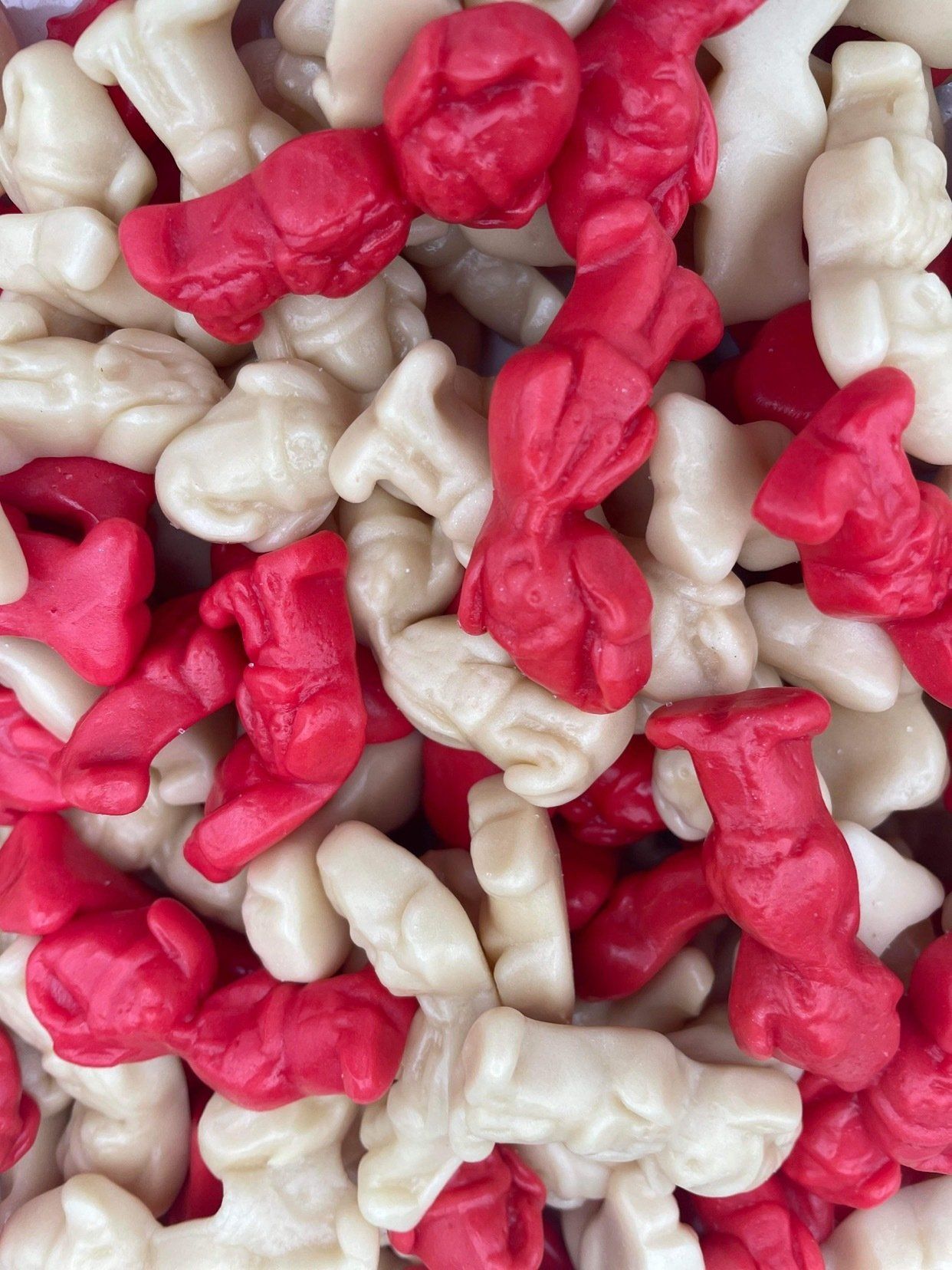 A pile of red and white gummy santa clauses