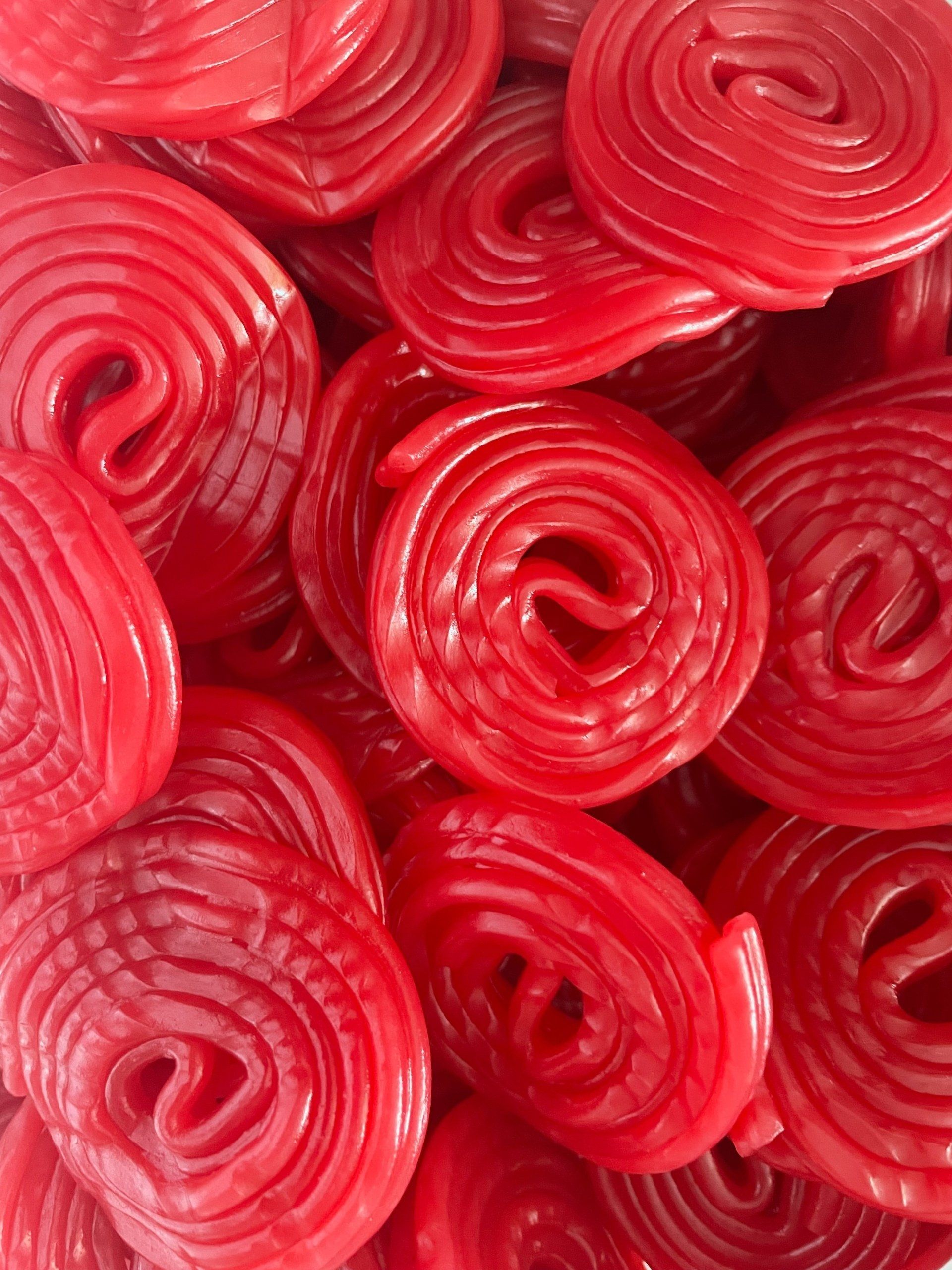 A close up of a pile of red candy swirls.