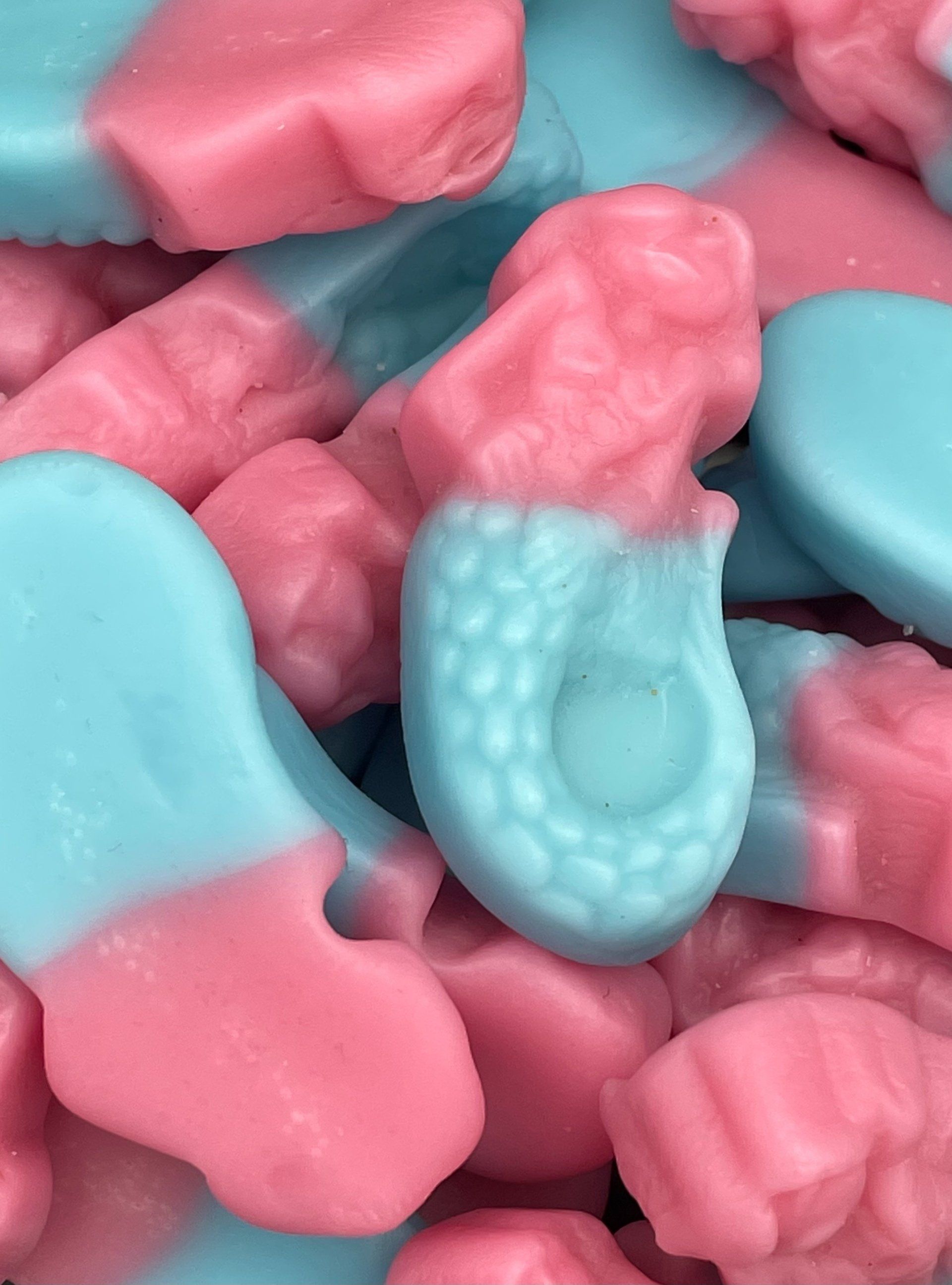 A close up of a pile of pink and blue gummy candies