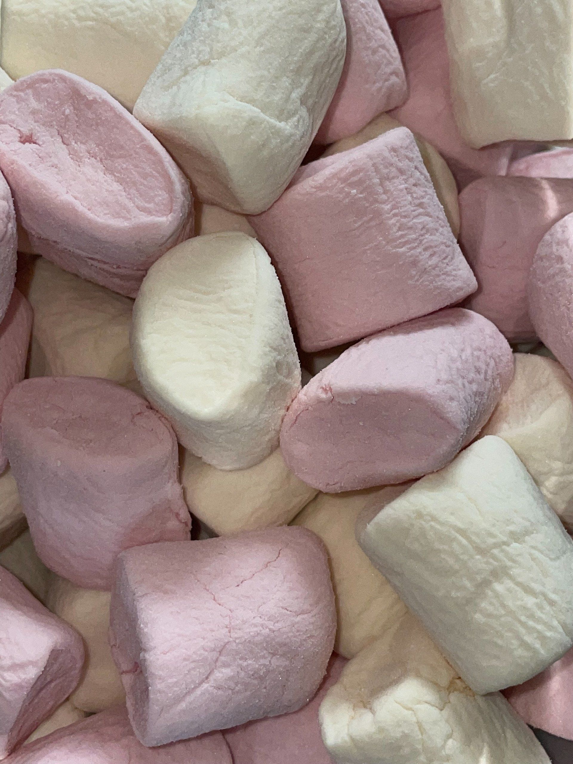A pile of pink and white marshmallows on a table.