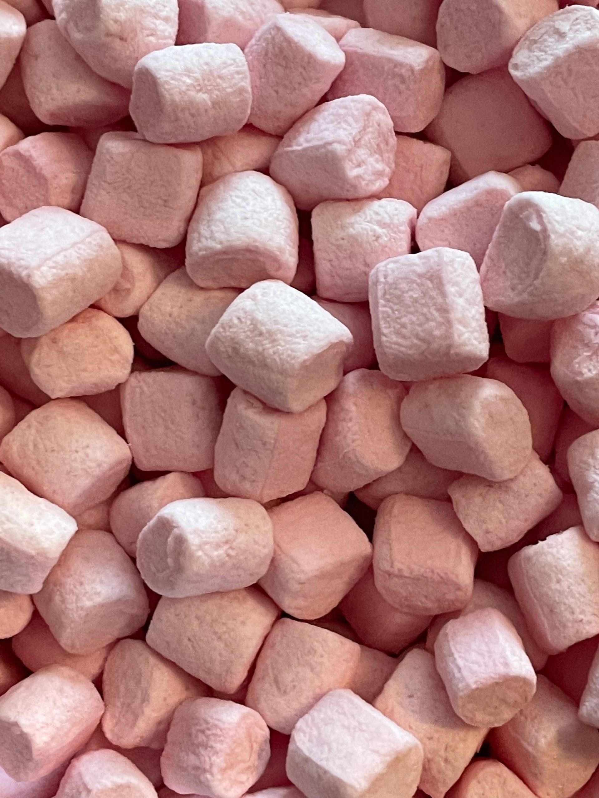 A pile of pink marshmallows are stacked on top of each other.