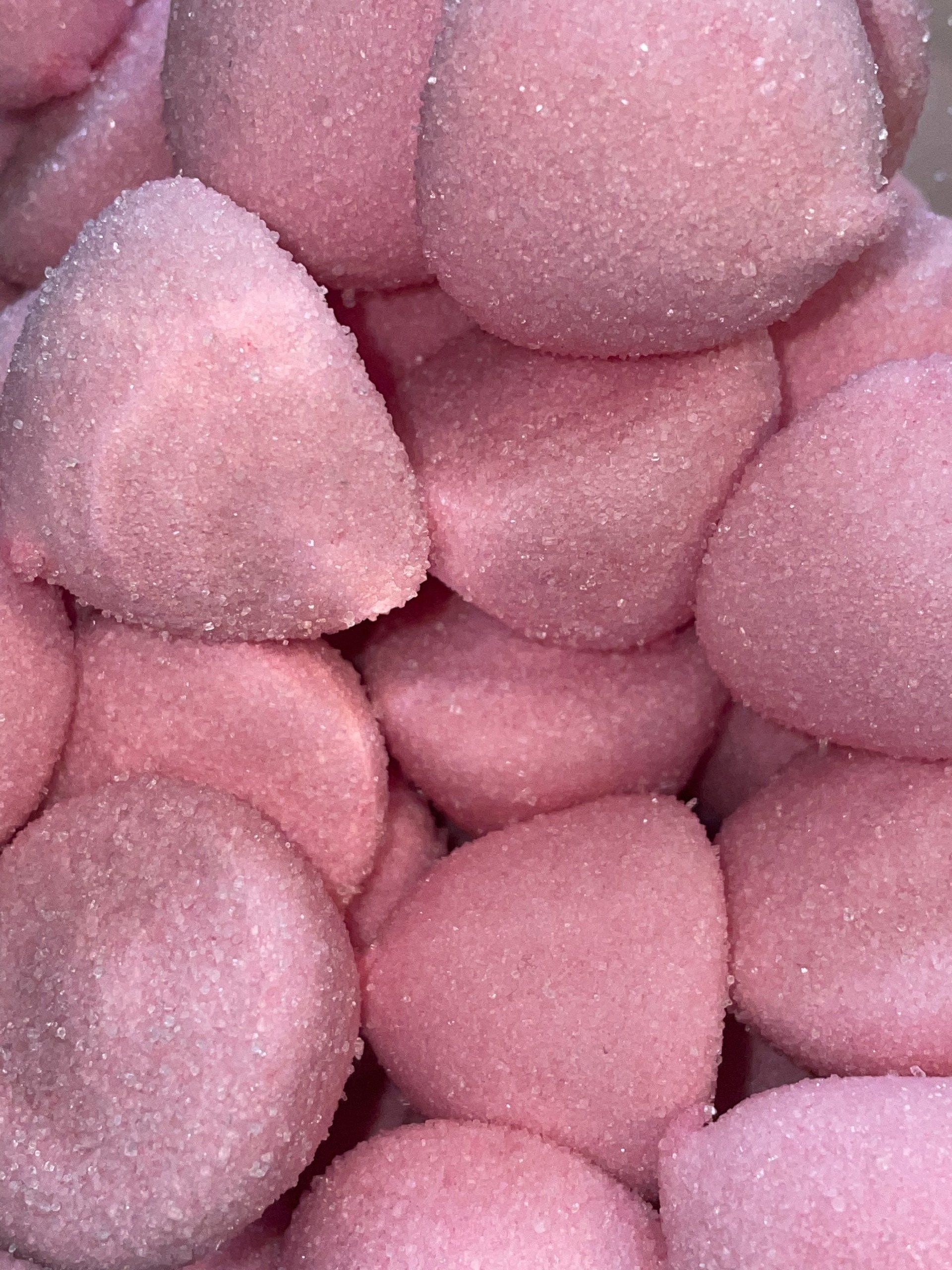 A pile of pink marshmallows are stacked on top of each other.