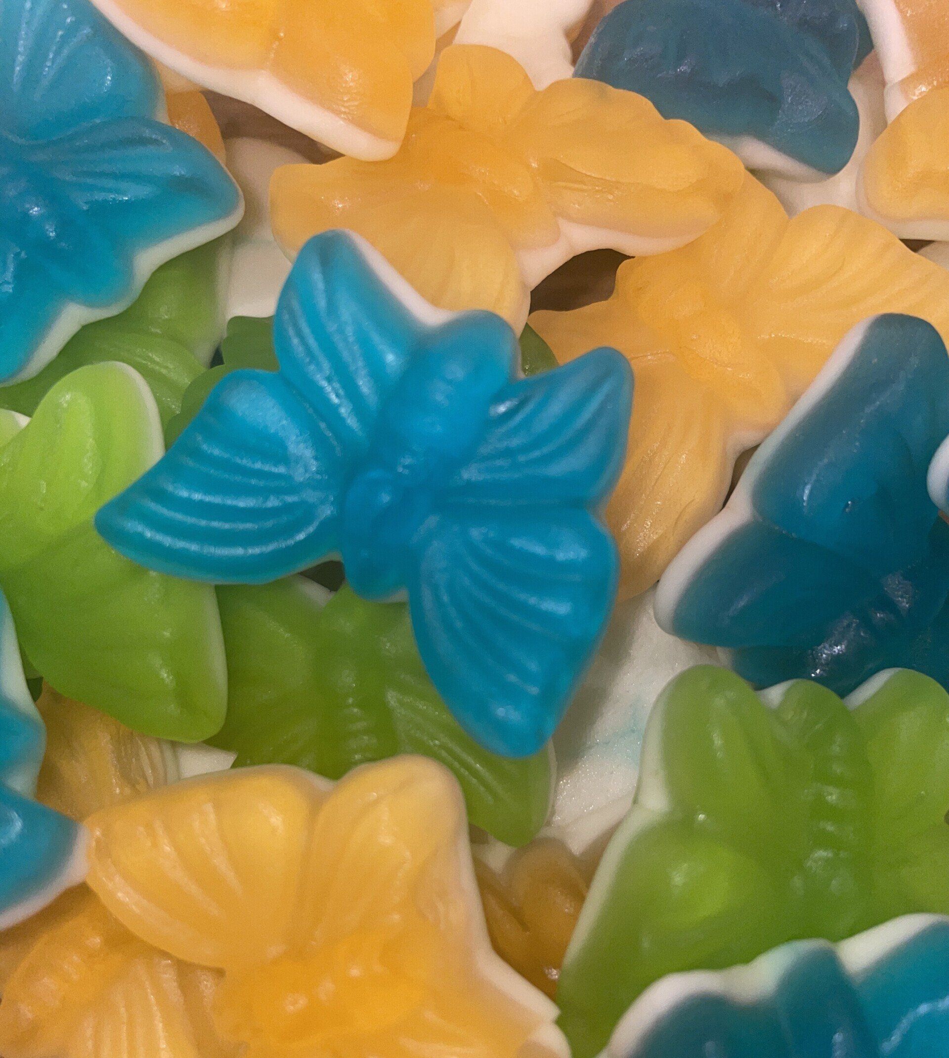 A close up of a pile of gummy flowers in different colors