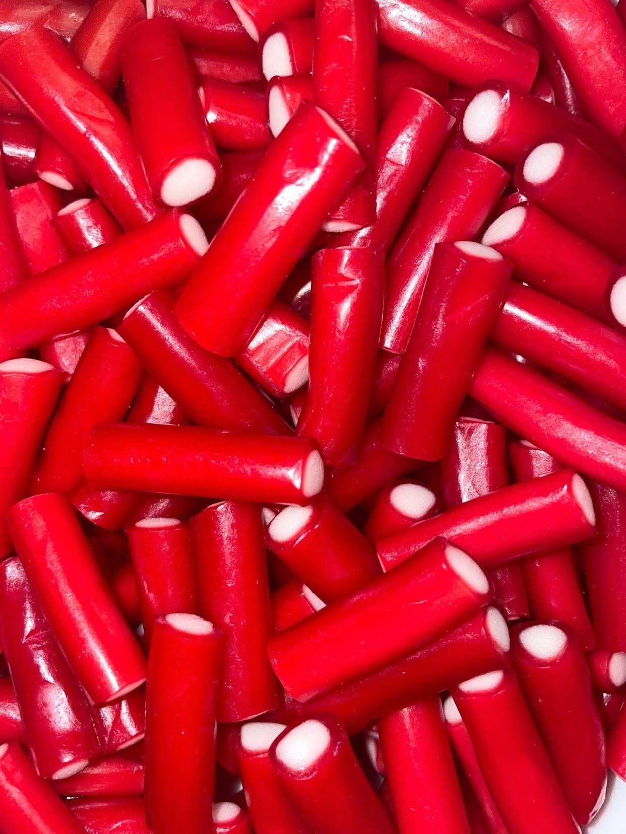 A pile of red sticks with white spots on them
