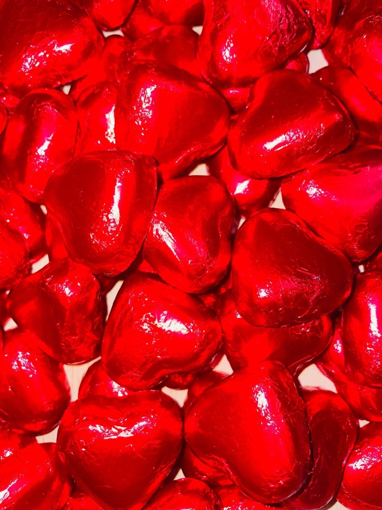 A pile of red hearts wrapped in red foil