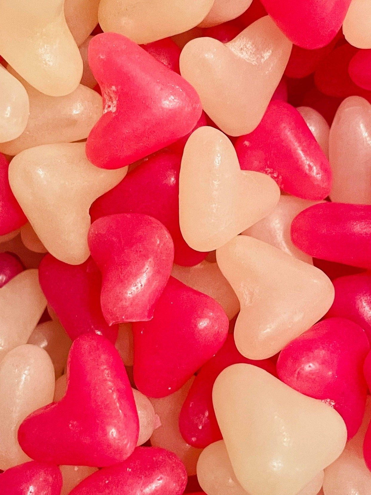 A pile of pink and white heart shaped candy