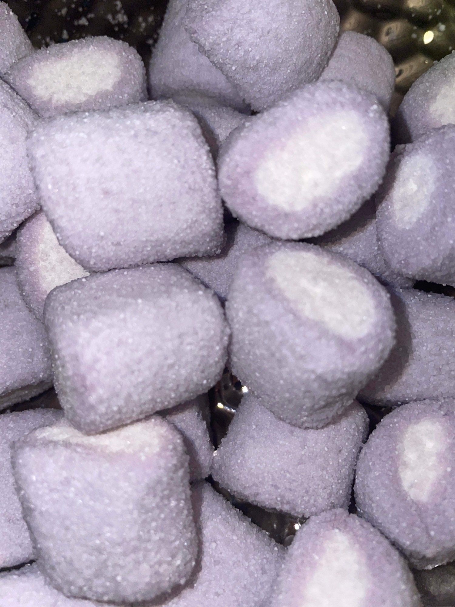 A pile of purple and white marshmallows on a table.