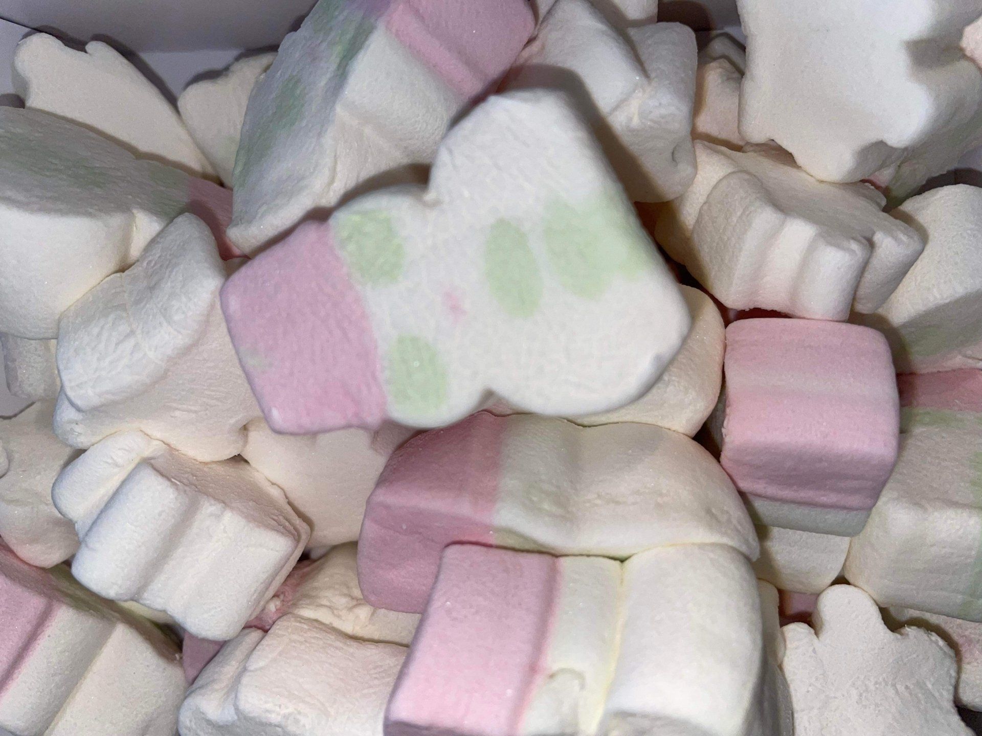 A pile of pink and white marshmallows in the shape of a teddy bear.