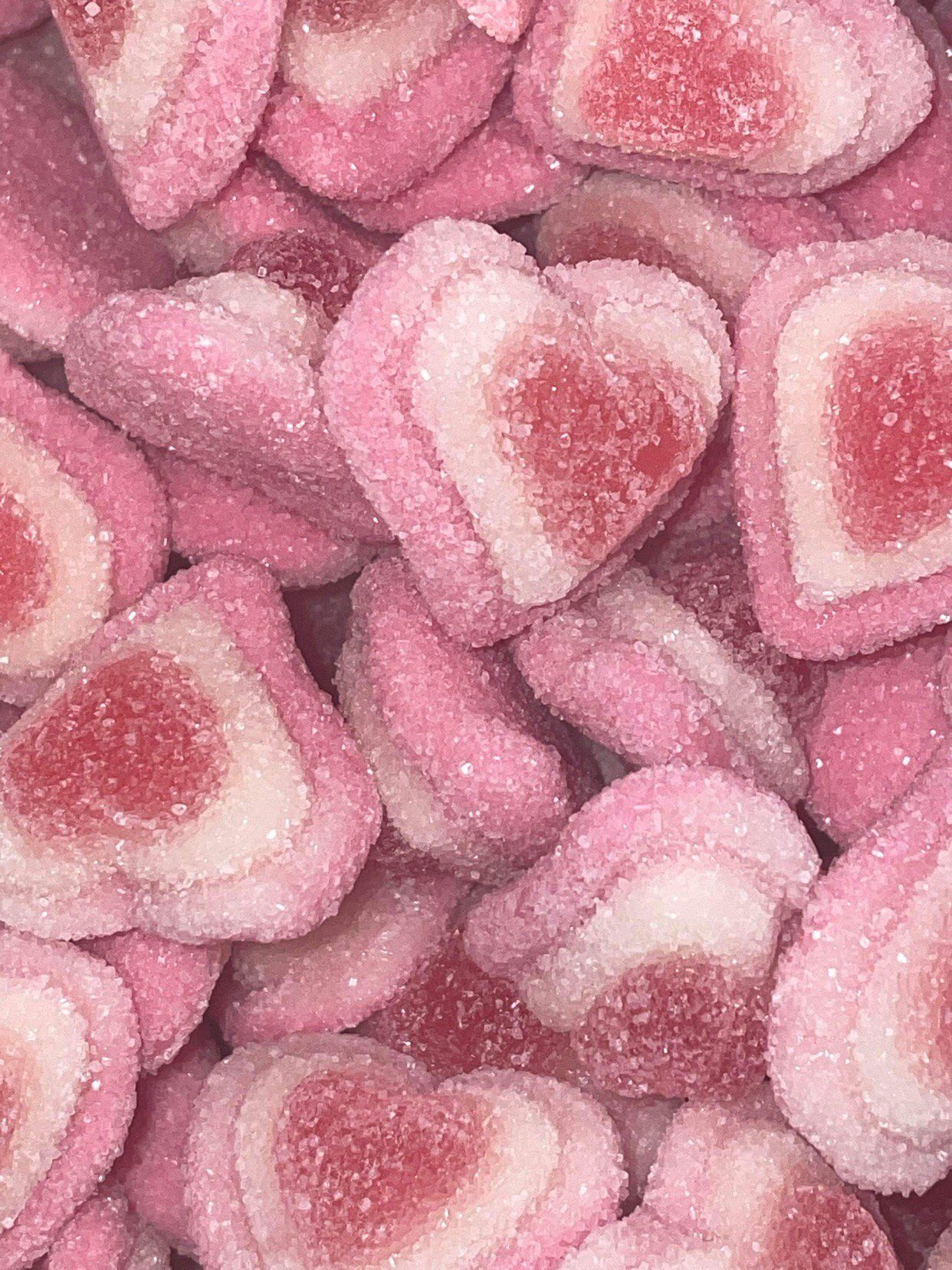 A pile of pink and white heart shaped gummy candies.
