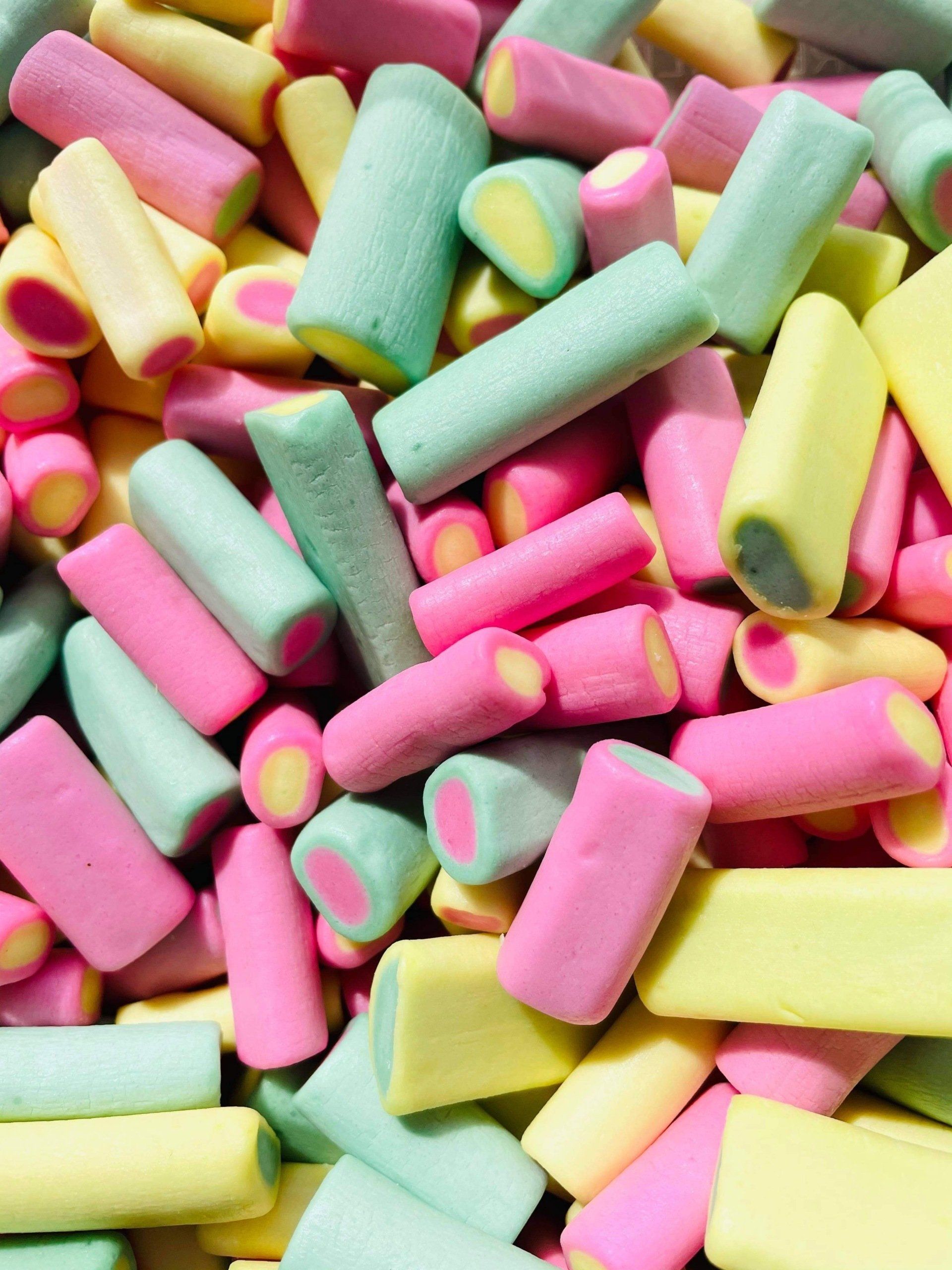 A pile of pink , yellow and green marshmallows