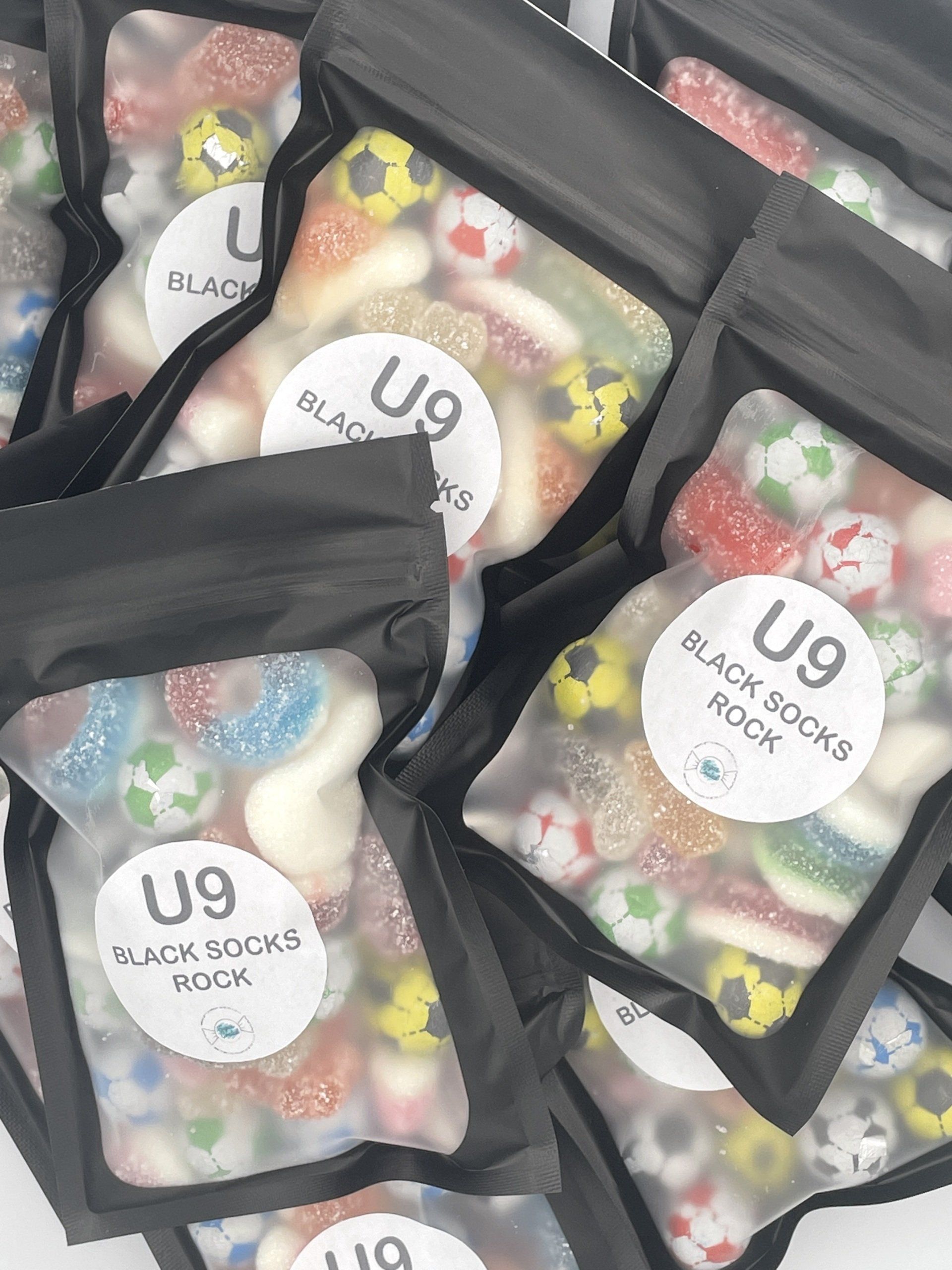 A bunch of bags of candy with soccer balls on them.