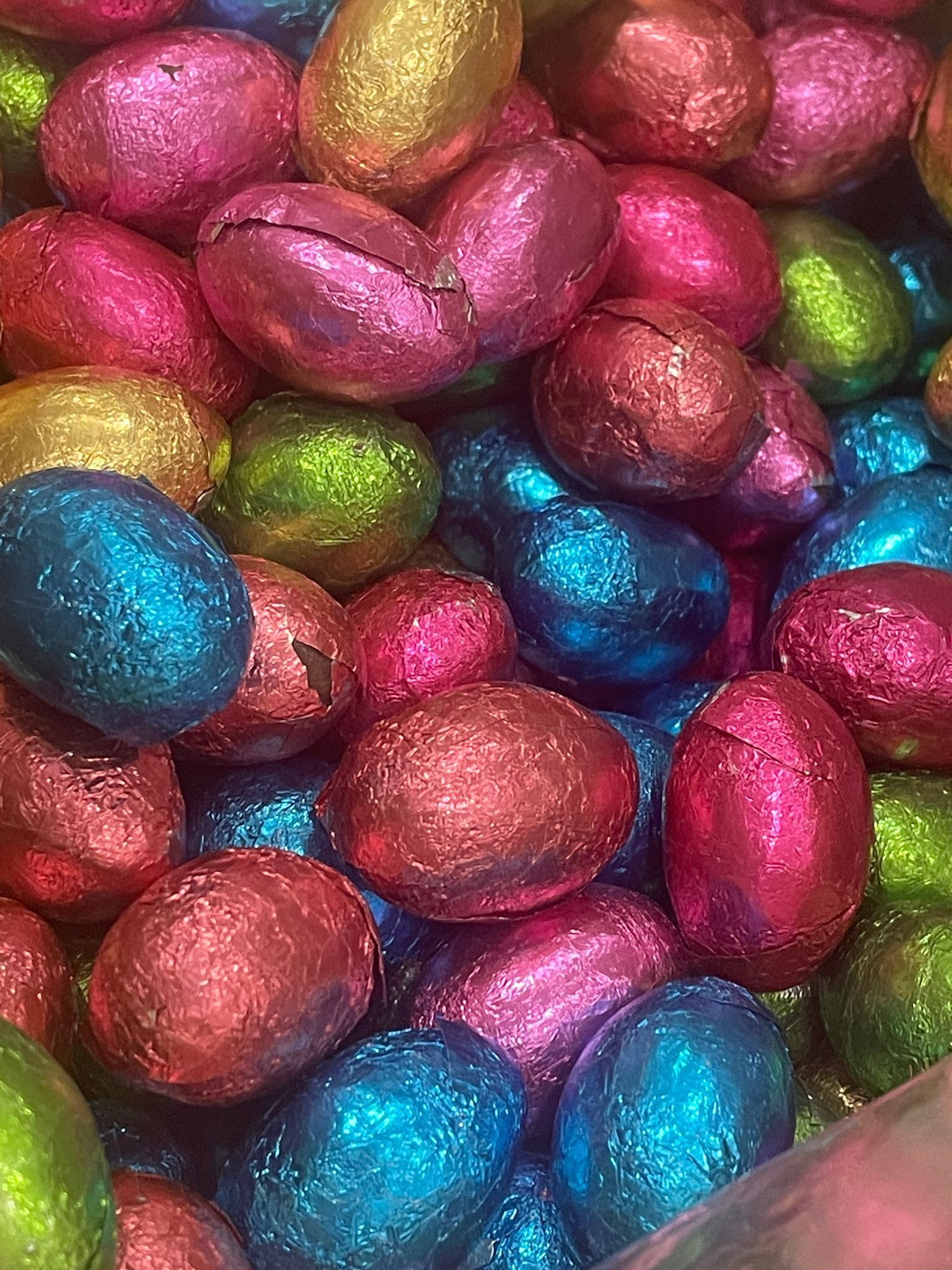 A pile of colorful chocolate eggs wrapped in foil.