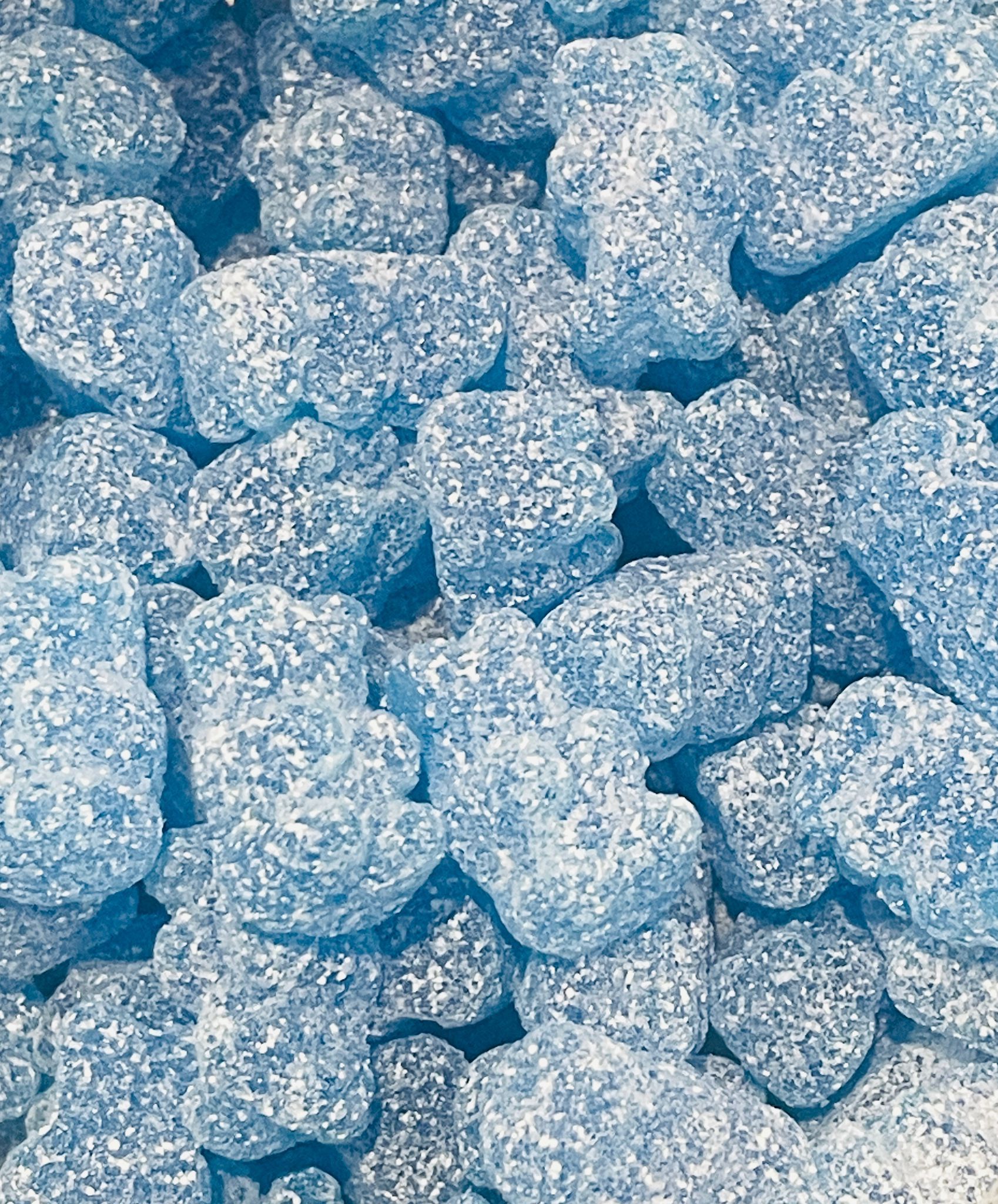 A close up of a pile of blue gummy bears.
