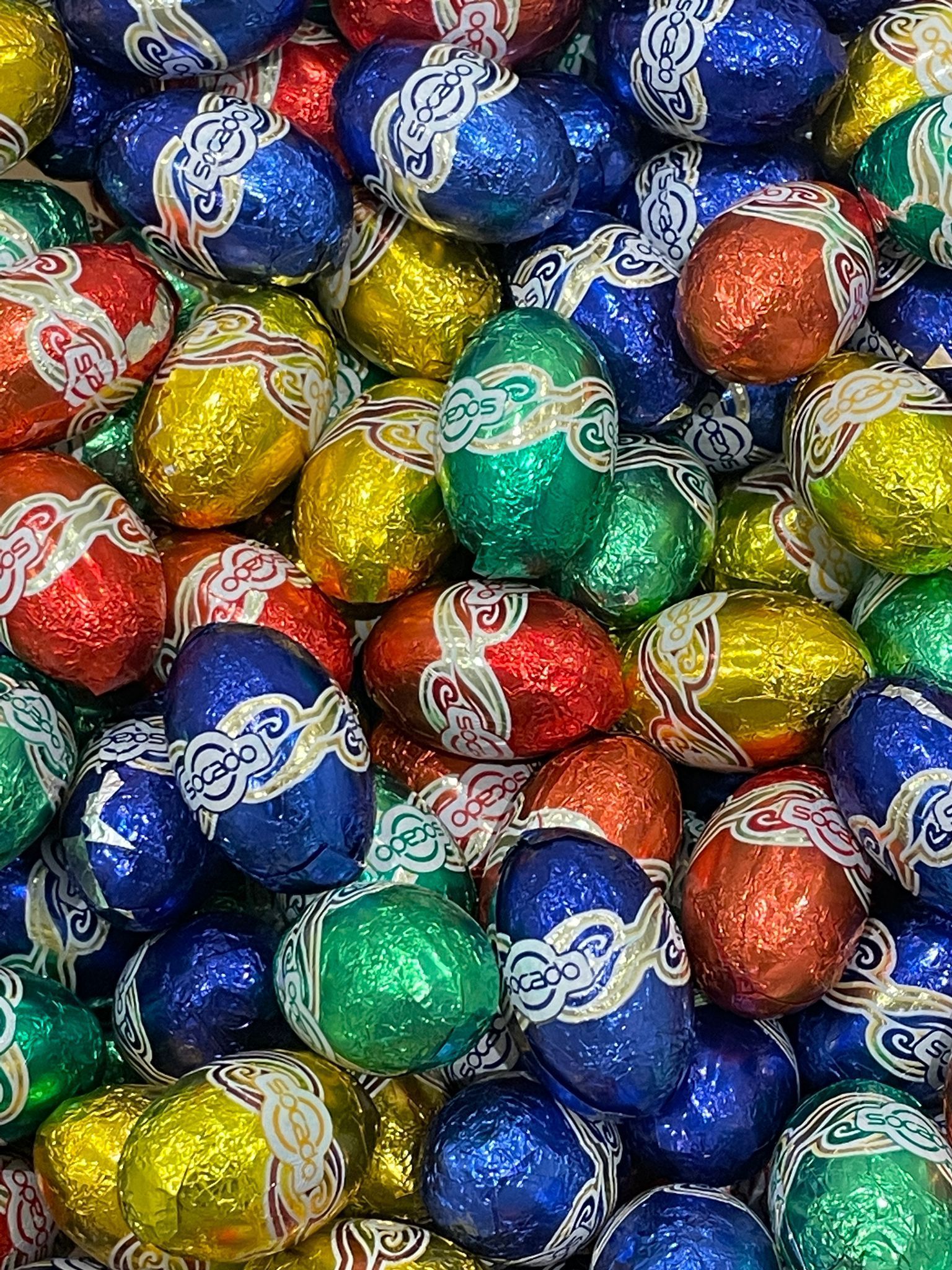 A pile of colorful chocolate easter eggs wrapped in foil.