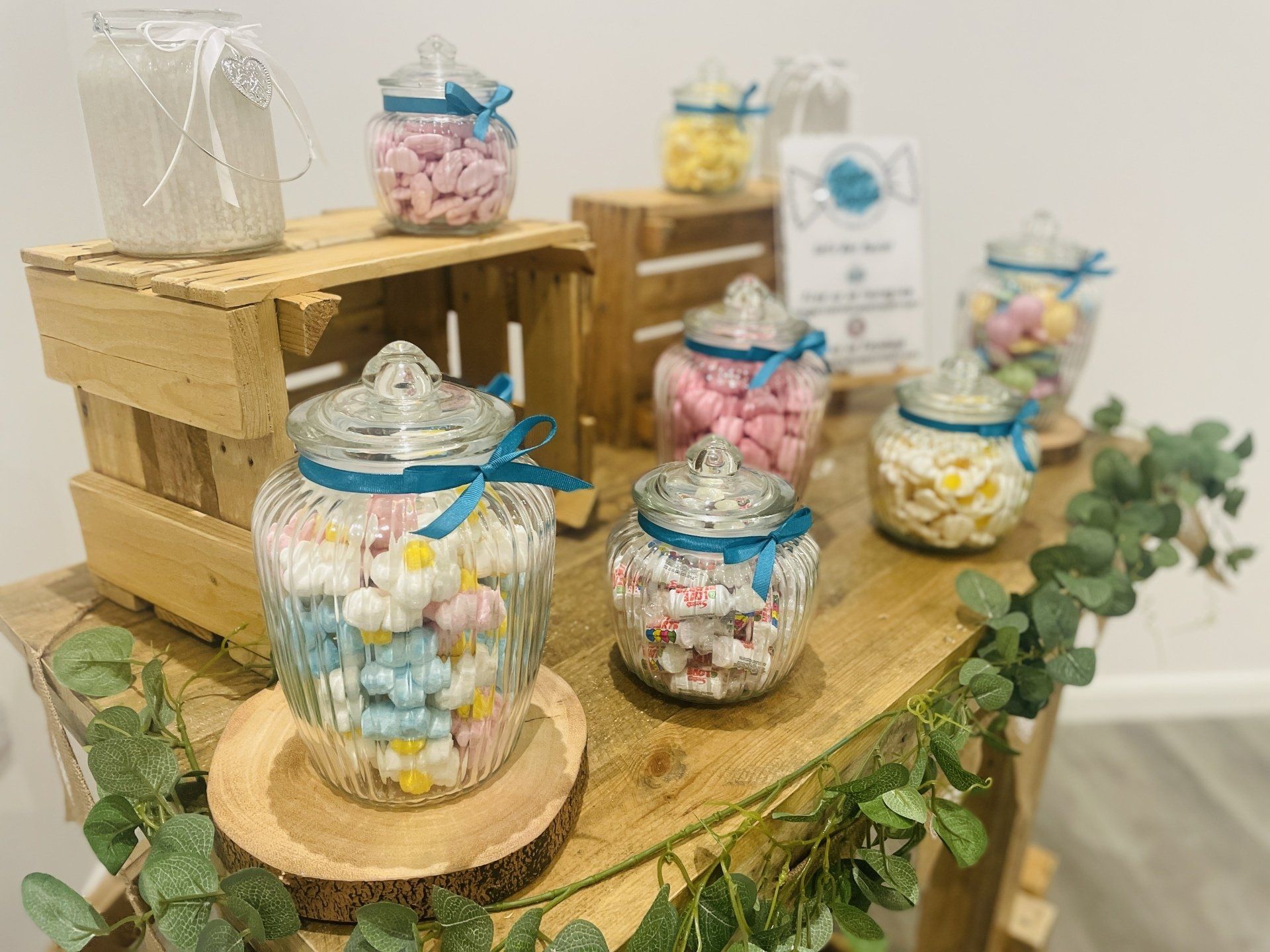 there are many jars of candy on the table .