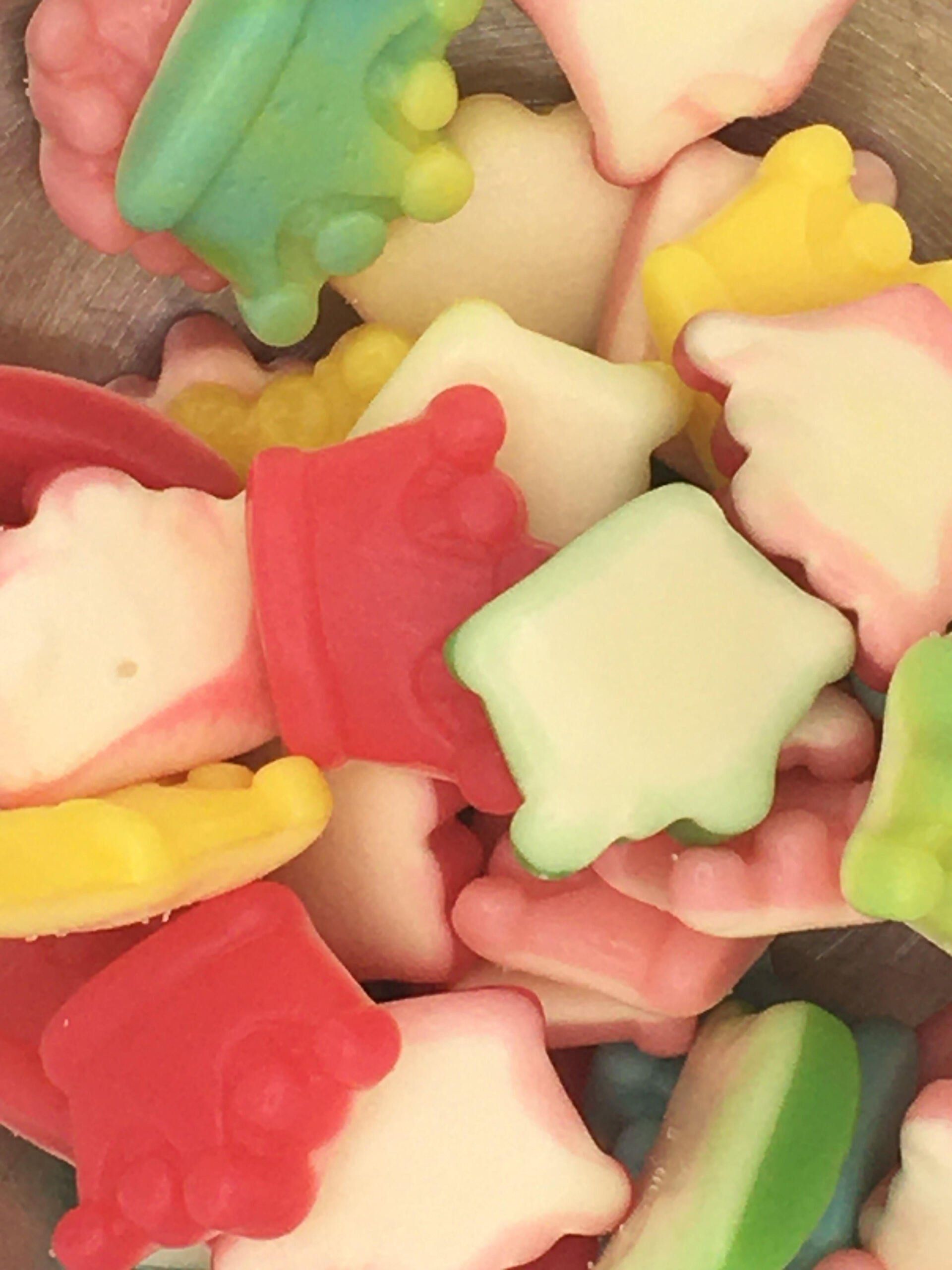 A pile of colorful gummy bears with crowns on them