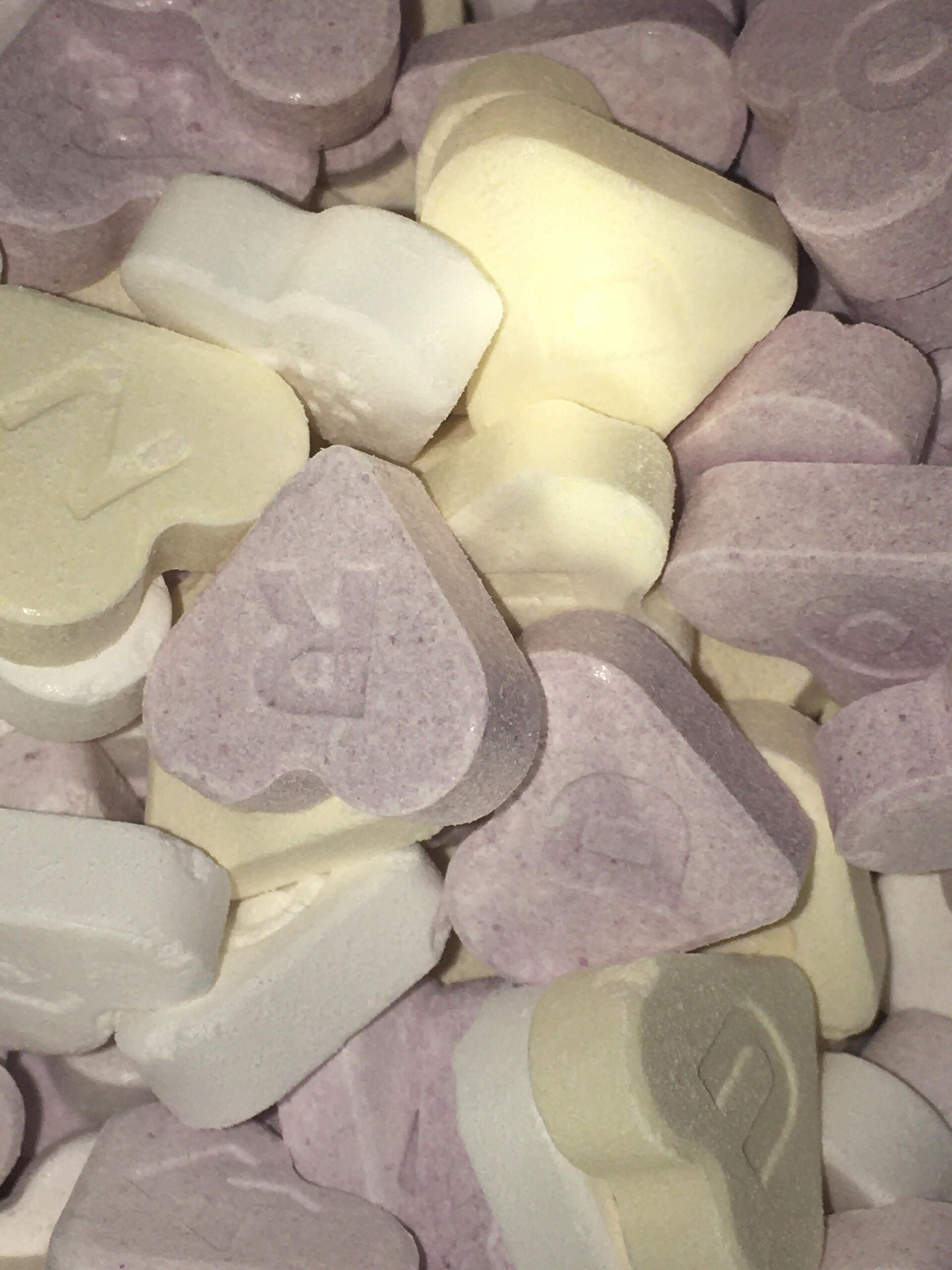 A pile of candy hearts with the letter r on them