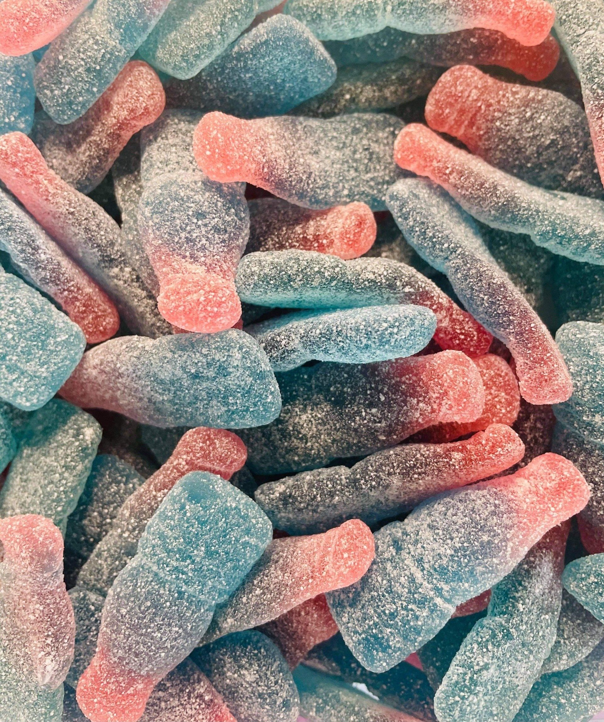 A pile of blue and red gummy soda bottles.