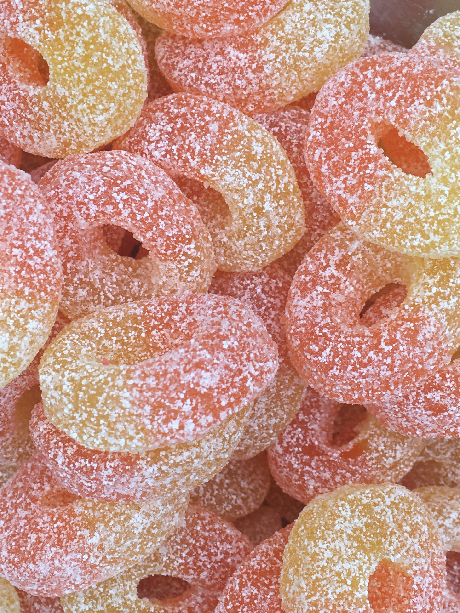 A close up of a pile of gummy pineapple rings covered in sugar.