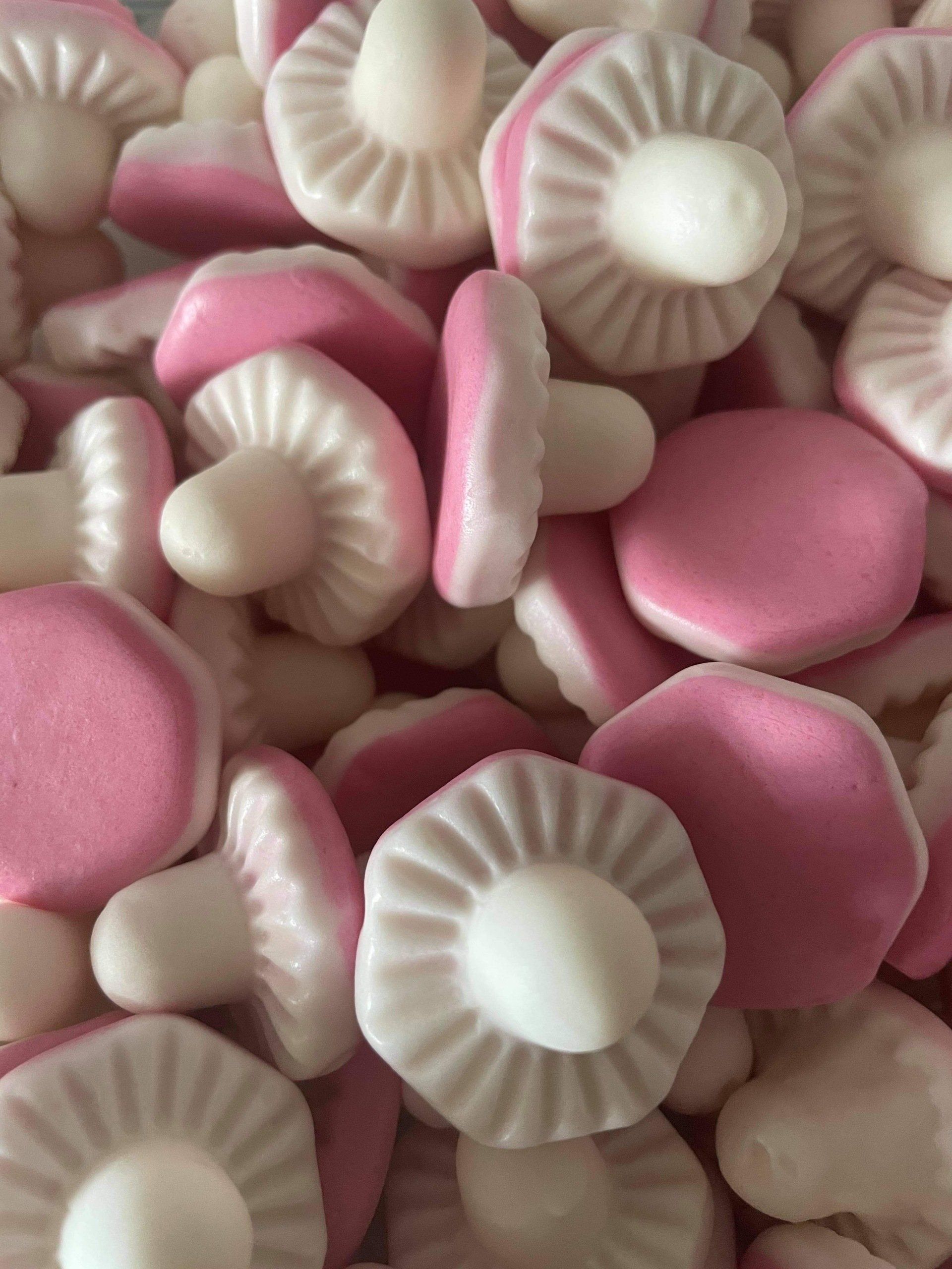 A pile of pink and white mushrooms on a table.