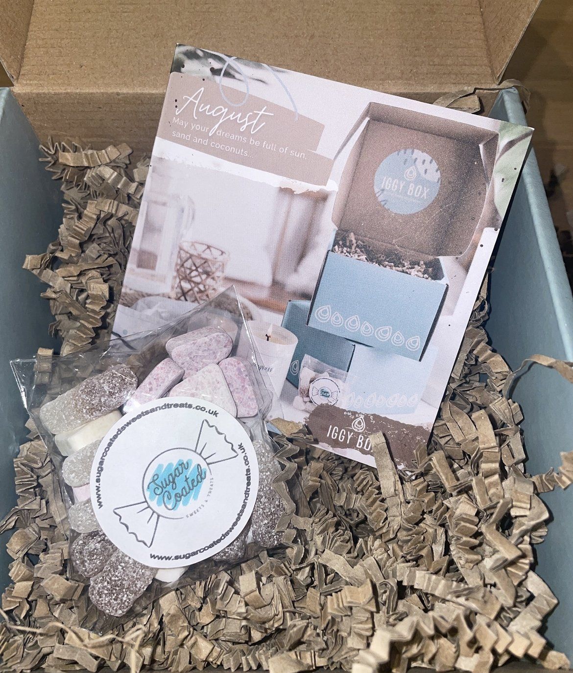 A box filled with shredded paper and a bag of candy.