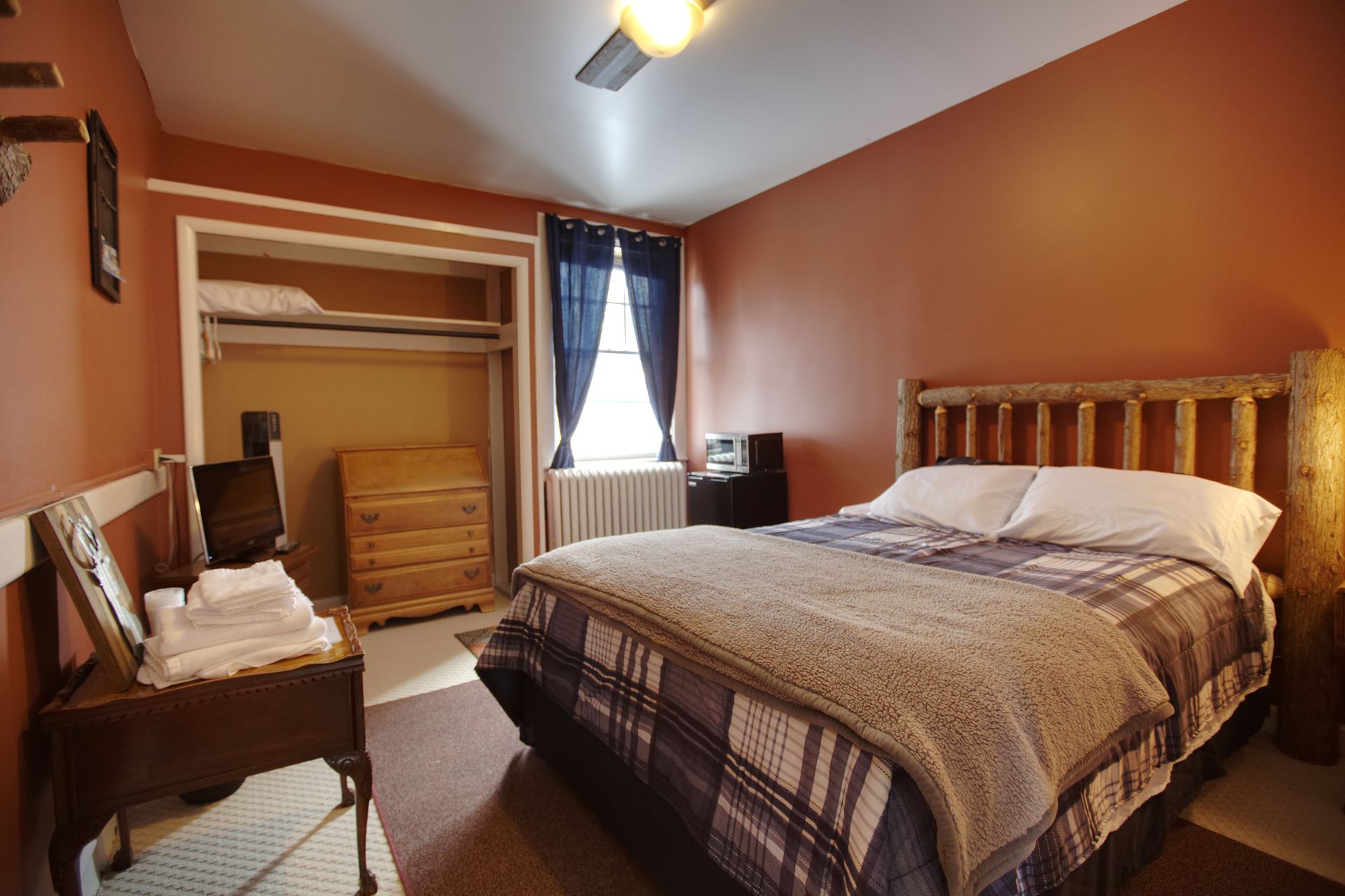 A bedroom with a king size bed and a ceiling fan