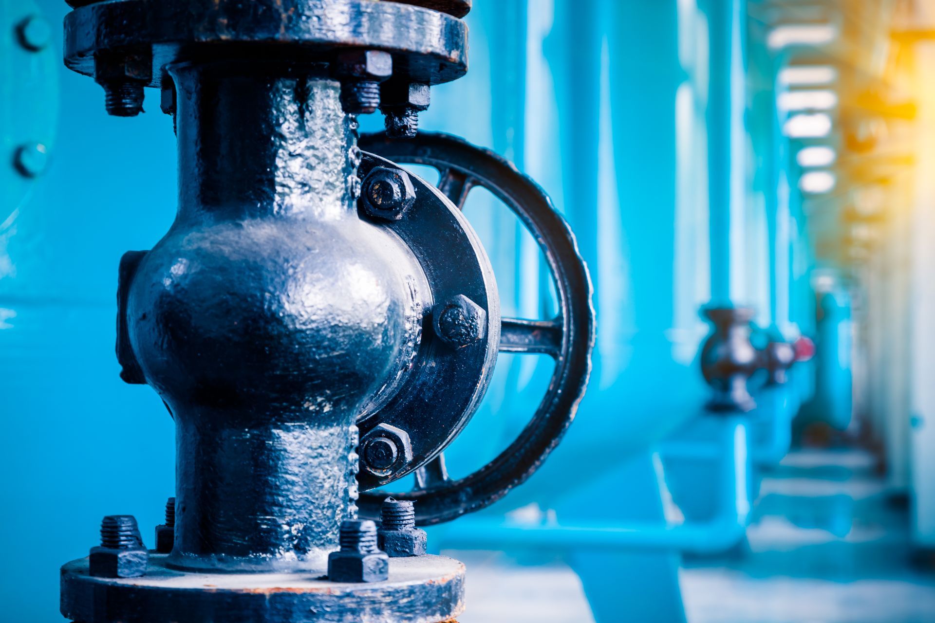 A close up of a valve on a pipe in a factory.