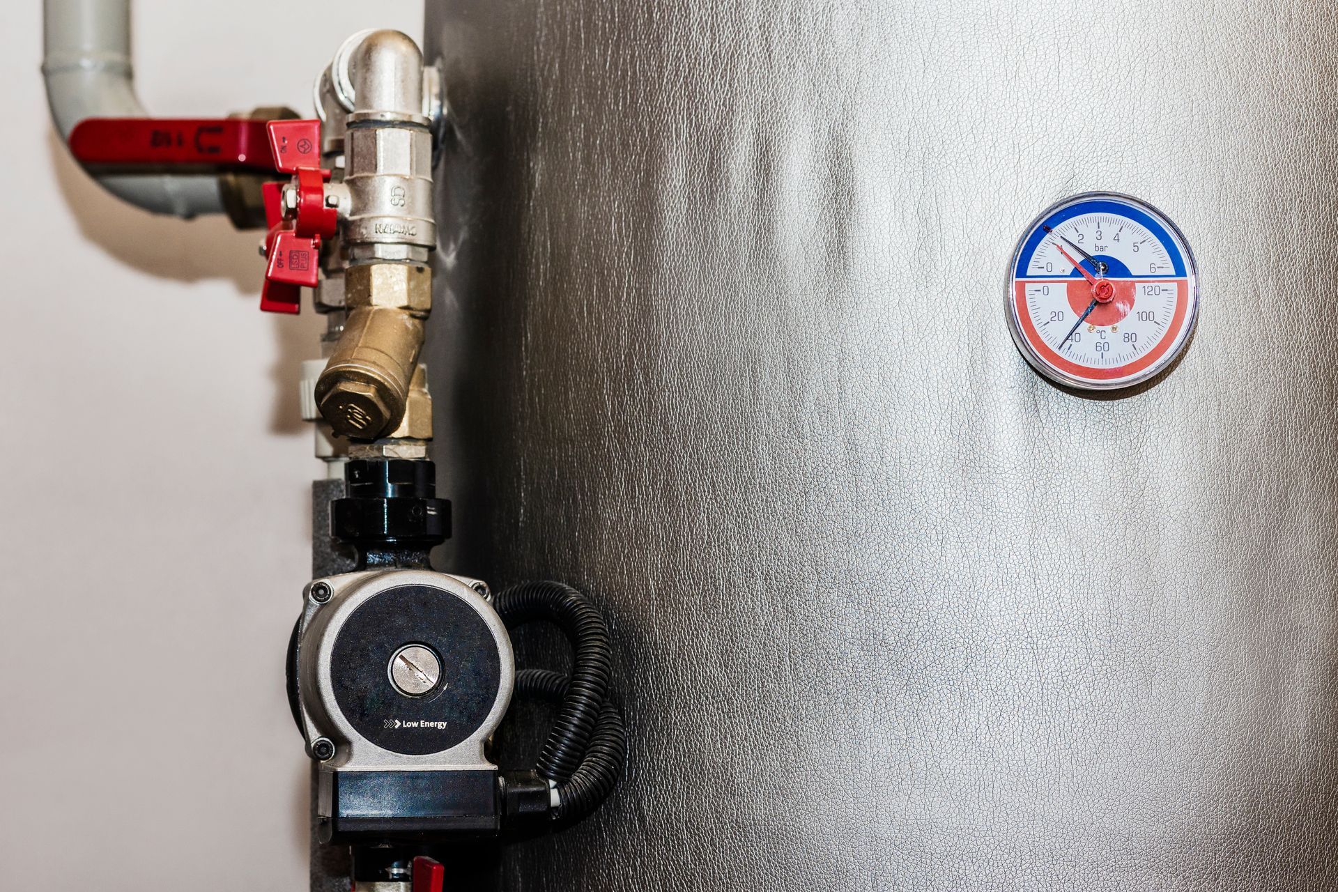A close up of a water heater with a thermometer on it.