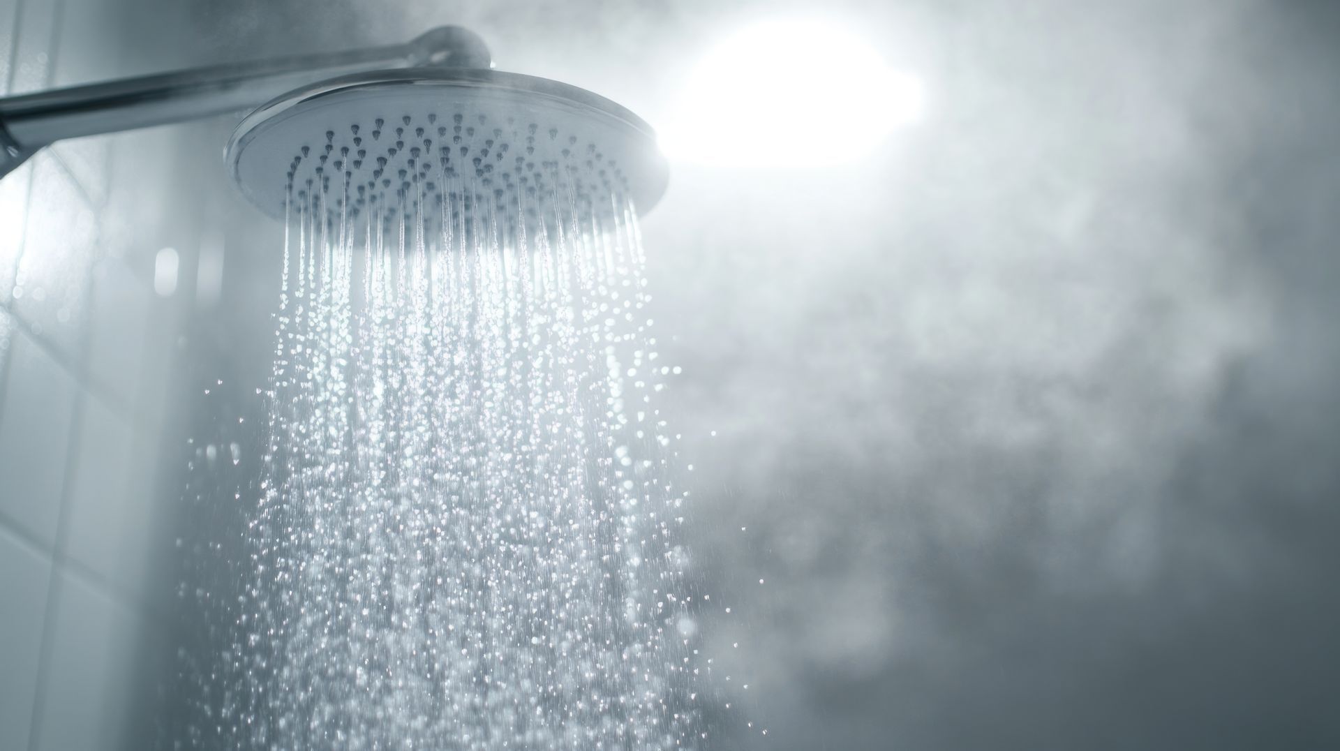 A close up of a shower head with water coming out of it.