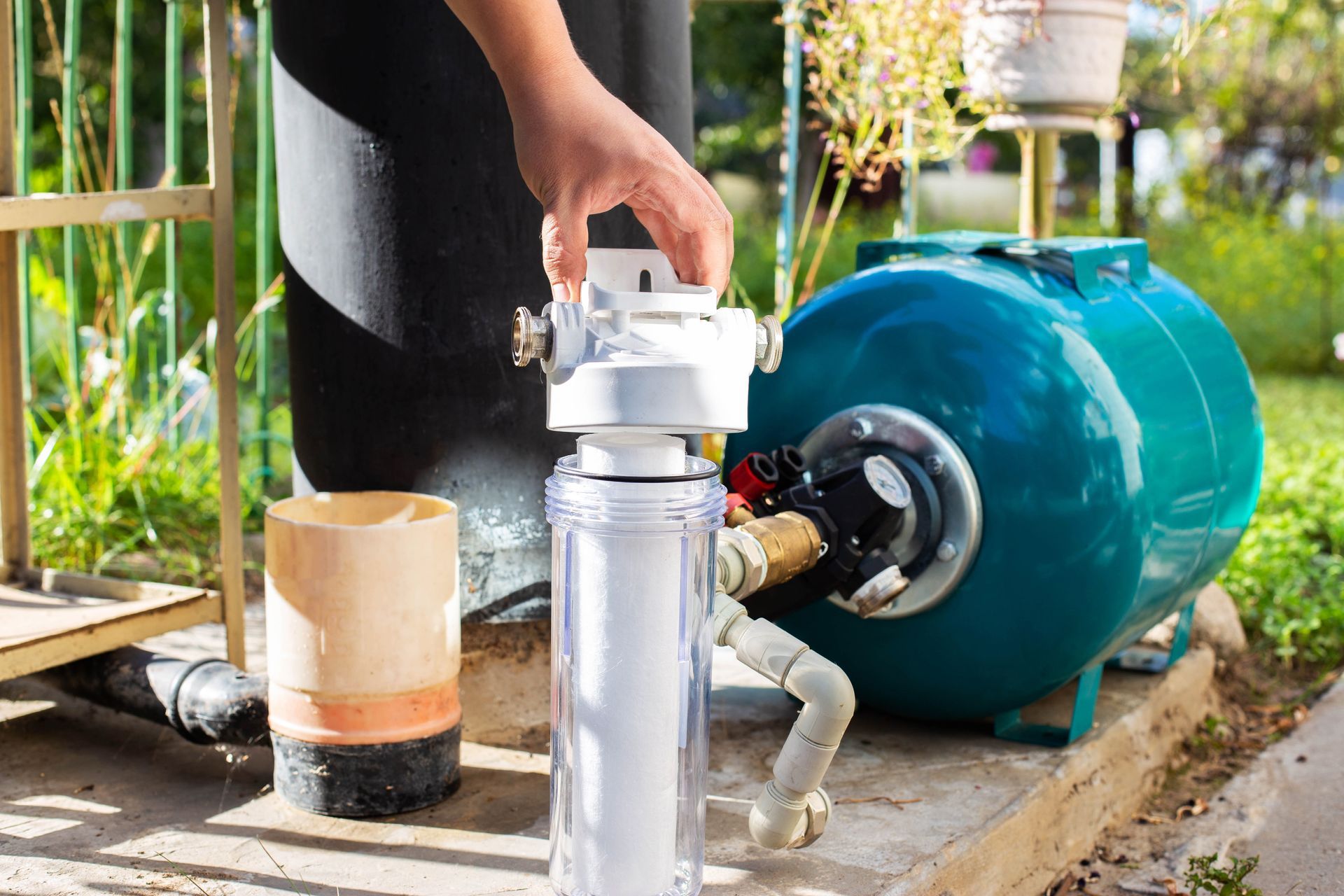 A person is installing a water filter on a water pump.