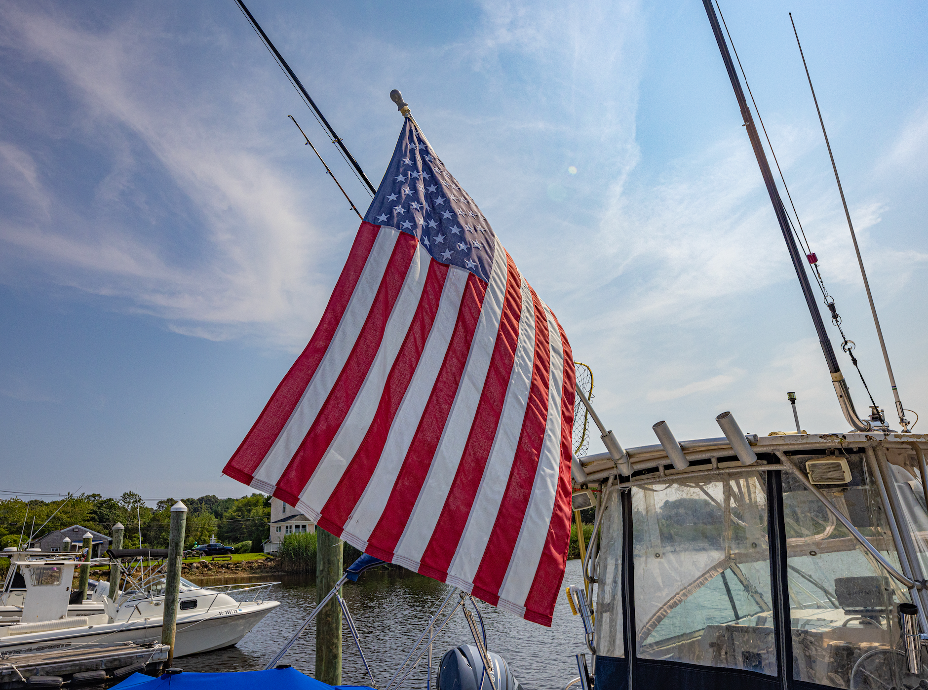 An american flag is flying on a boat in the water